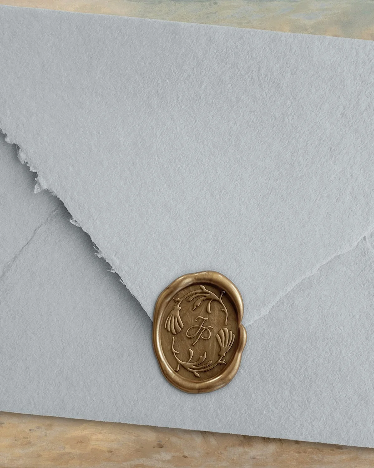 Wedding stationery branding featuring textured envelope with custom wax seal and coastal-inspired monogram for luxury artisan paper goods