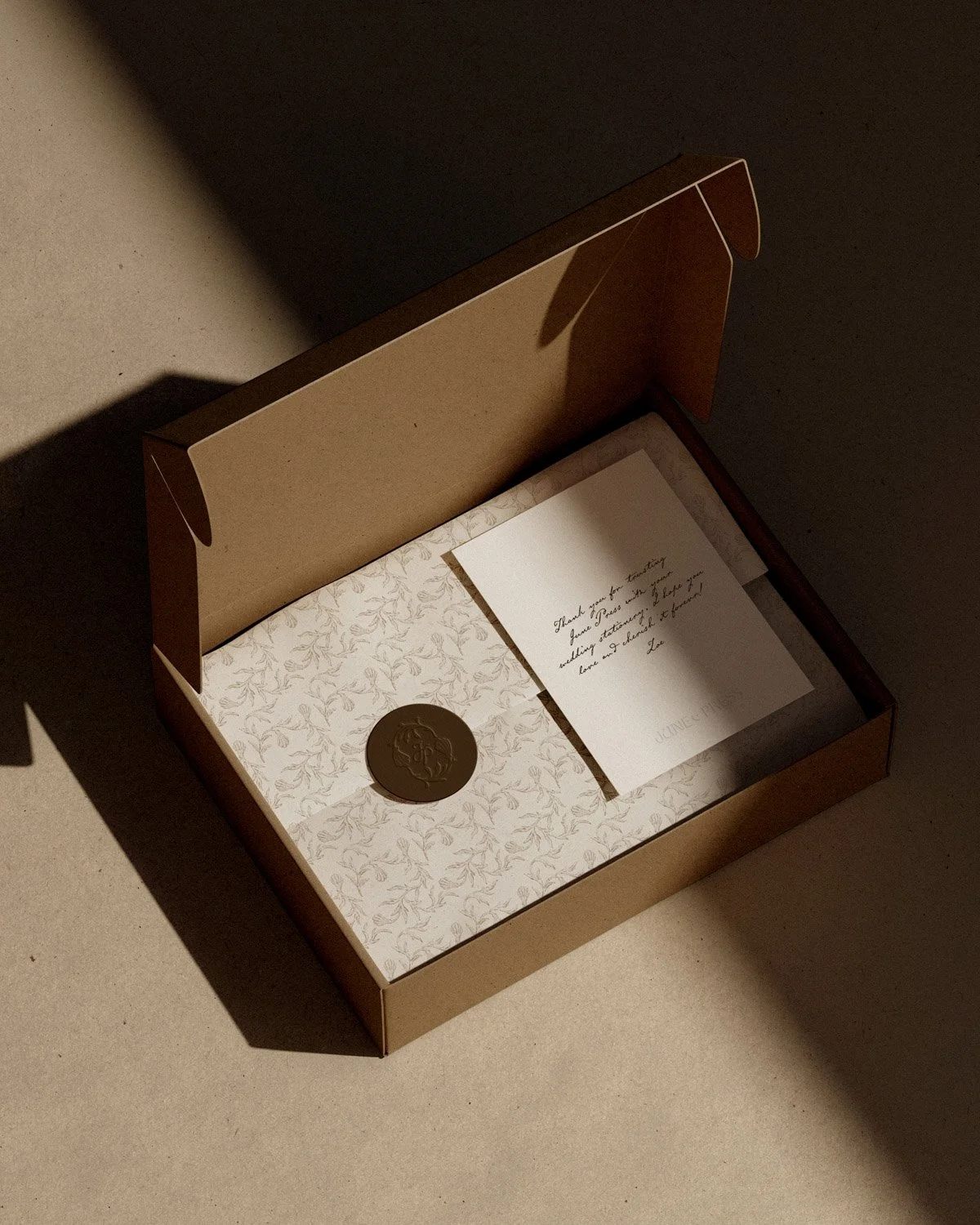 Luxury packaging design for June Press showcasing stationery box with botanical coastal pattern, wax seal, and natural textured materials