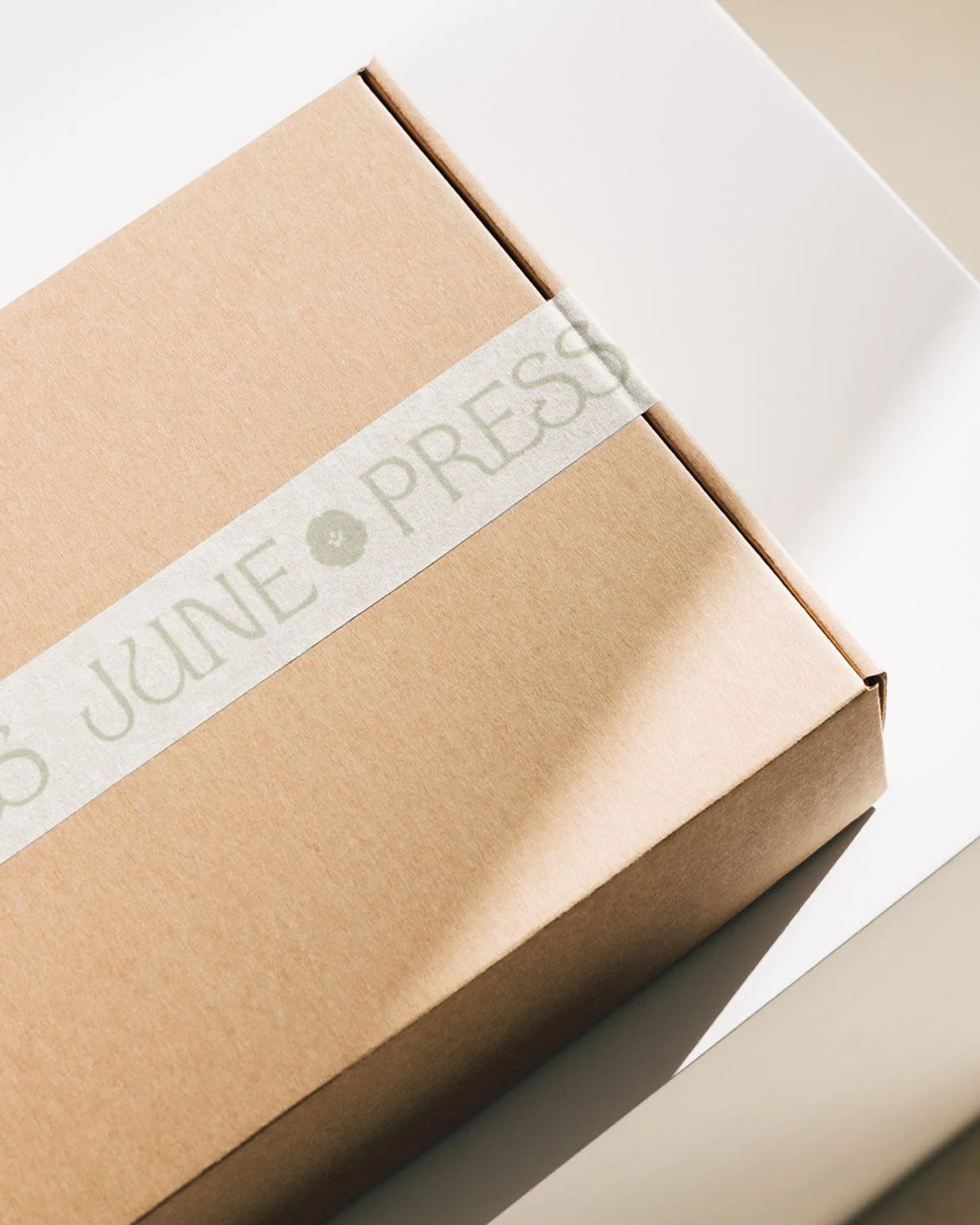 Packaging design for June Press featuring minimalist box with branded wrap and natural textures reflecting coastal-inspired artisan stationery