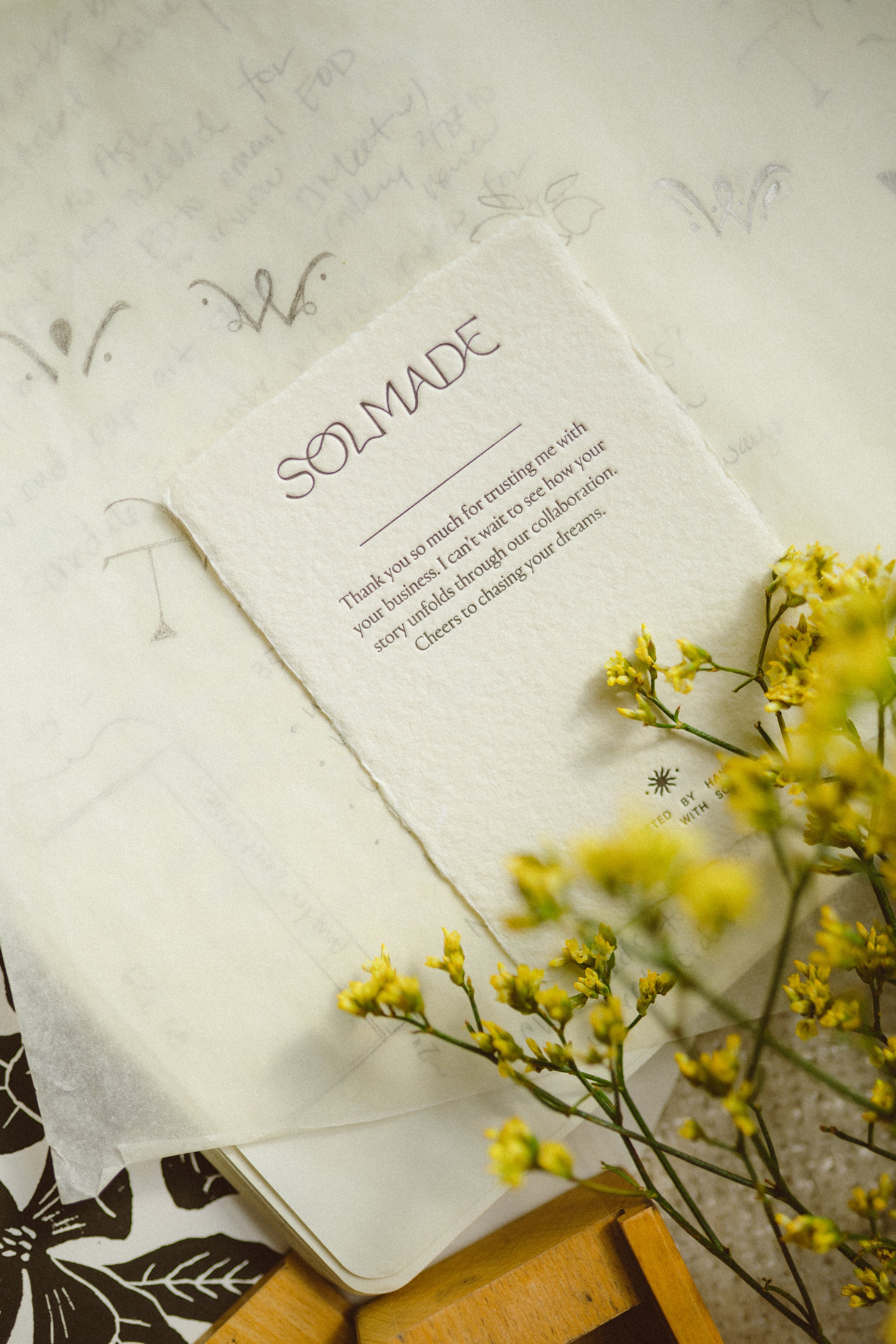 Custom stationery design featuring handmade deckled edge paper, Solmade brand card with floral styling and artisan branding details