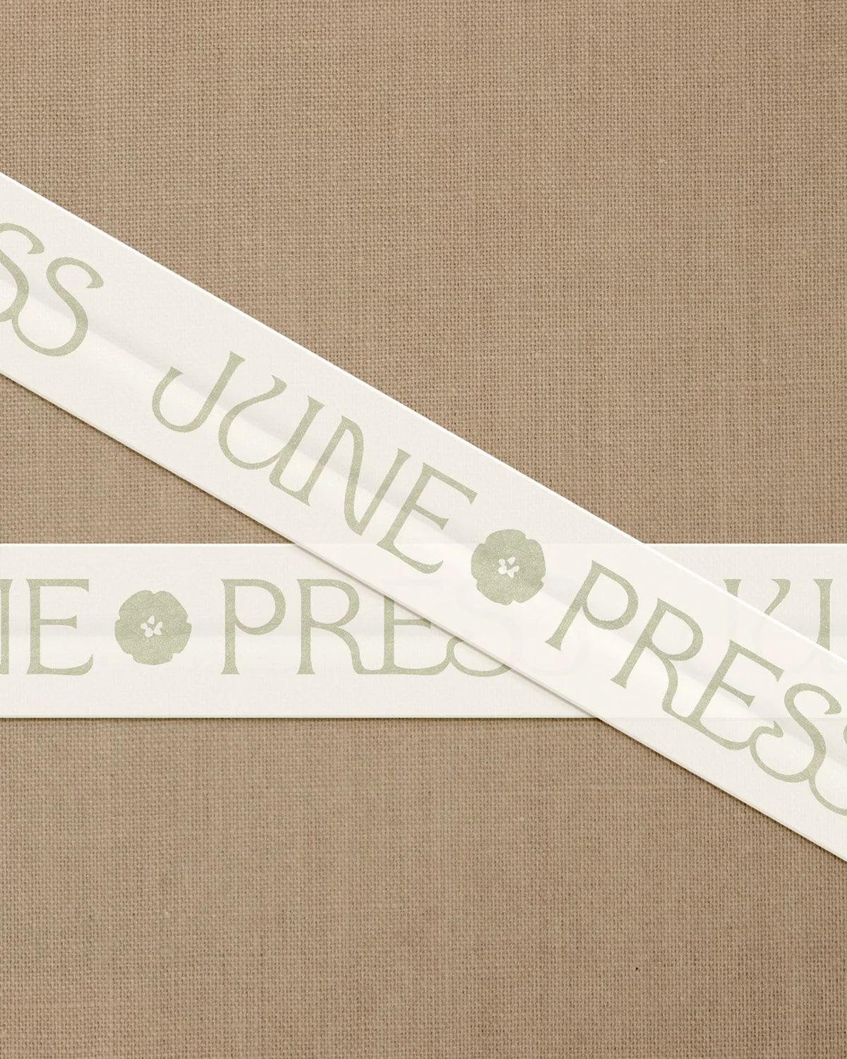Branding detail for June Press featuring custom ribbon with logo typography and soft natural tones reflecting coastal-inspired stationery branding