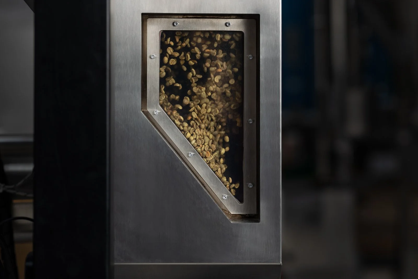 Coffee beans roasting in the stainless steel chamber of the NORDRE EMBLA, seen through the glass window