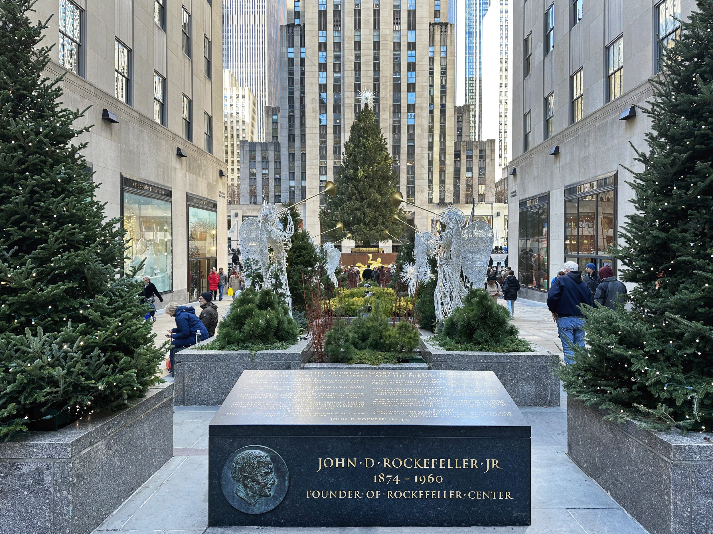 Channel Gardens at Rockefeller Center contains beautiful flower beds, trees, statues, and a marble fountain, surrounded by historical high-rise buildings in the heart of NYC. 