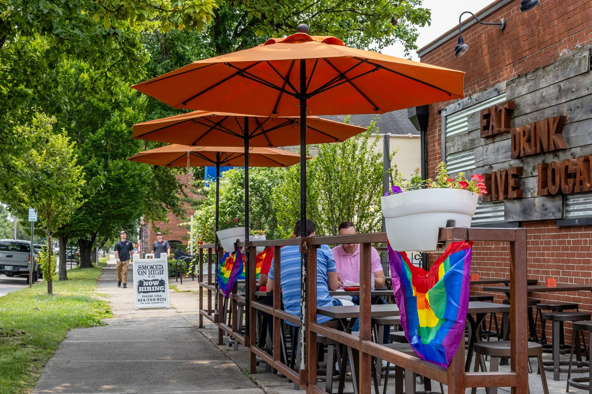 Outdoor patio seating at Local Cantina Brewery District on South High Street in Columbus, Ohio with orange umbrellas and patrons dining