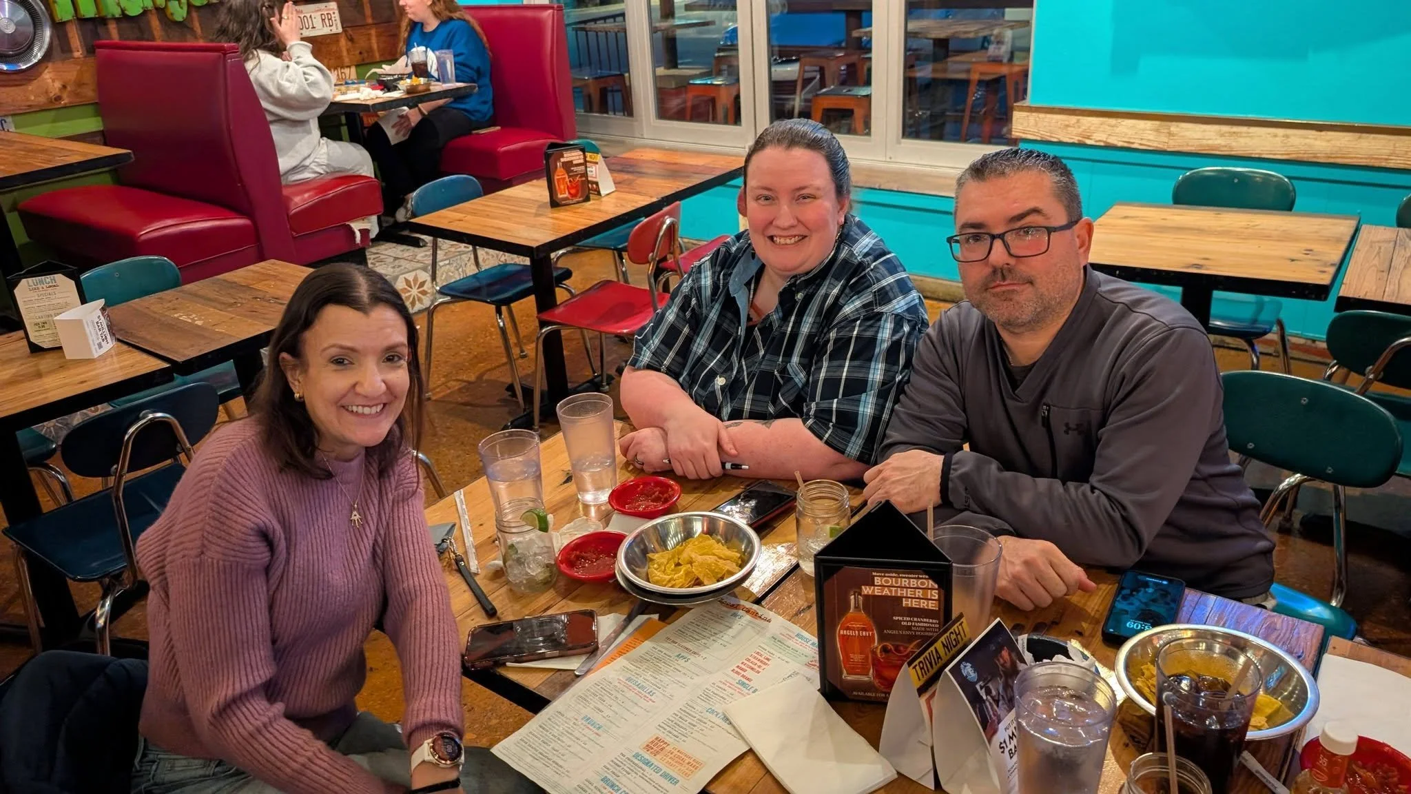Group of patrons enjoying chips, salsa, and drinks inside Local Cantina with menus and table seating in Columbus Ohio