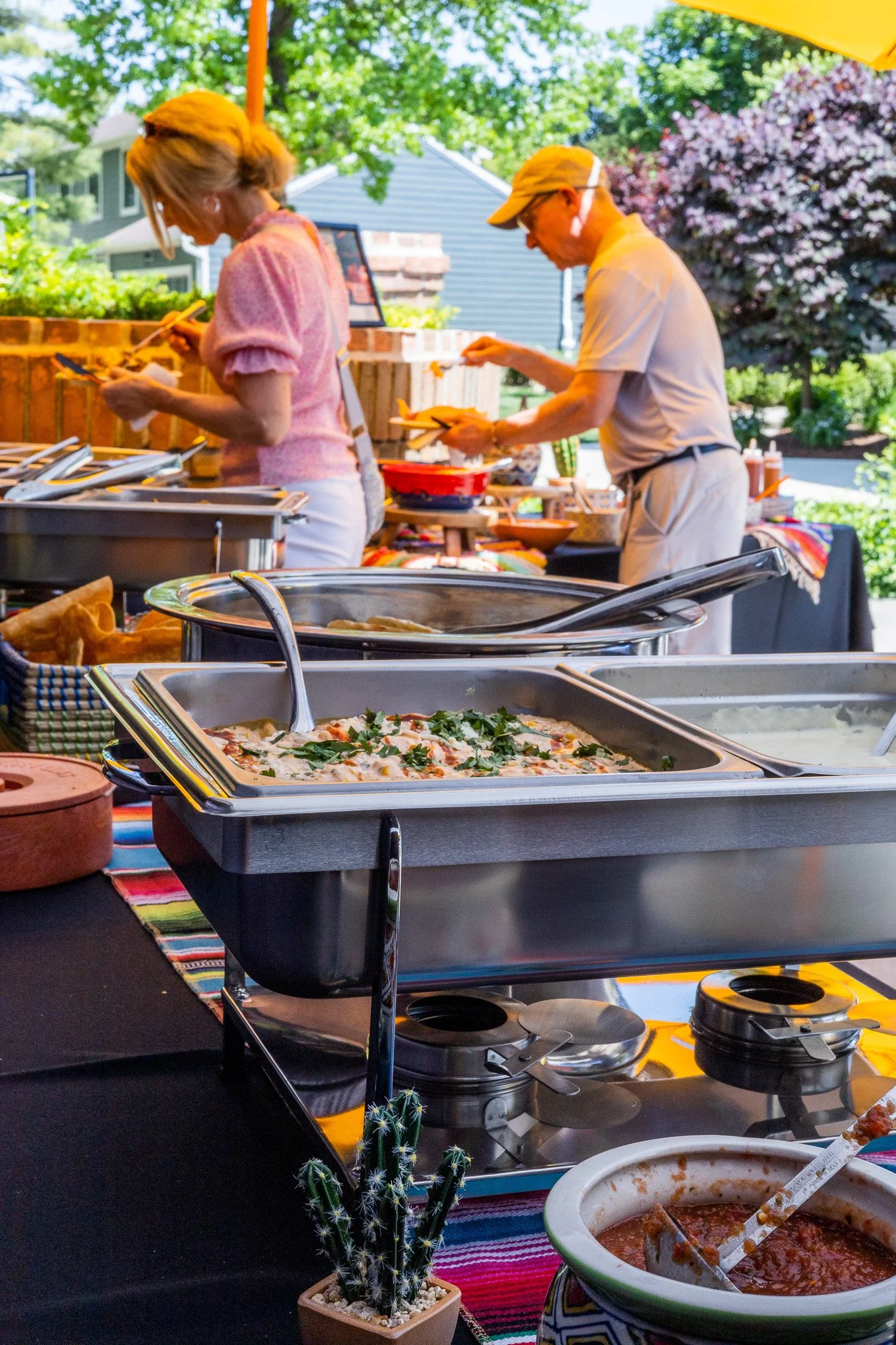 Local Cantina catered taco bar buffet with hot trays, queso, and toppings set up for an outdoor event in Columbus Ohio