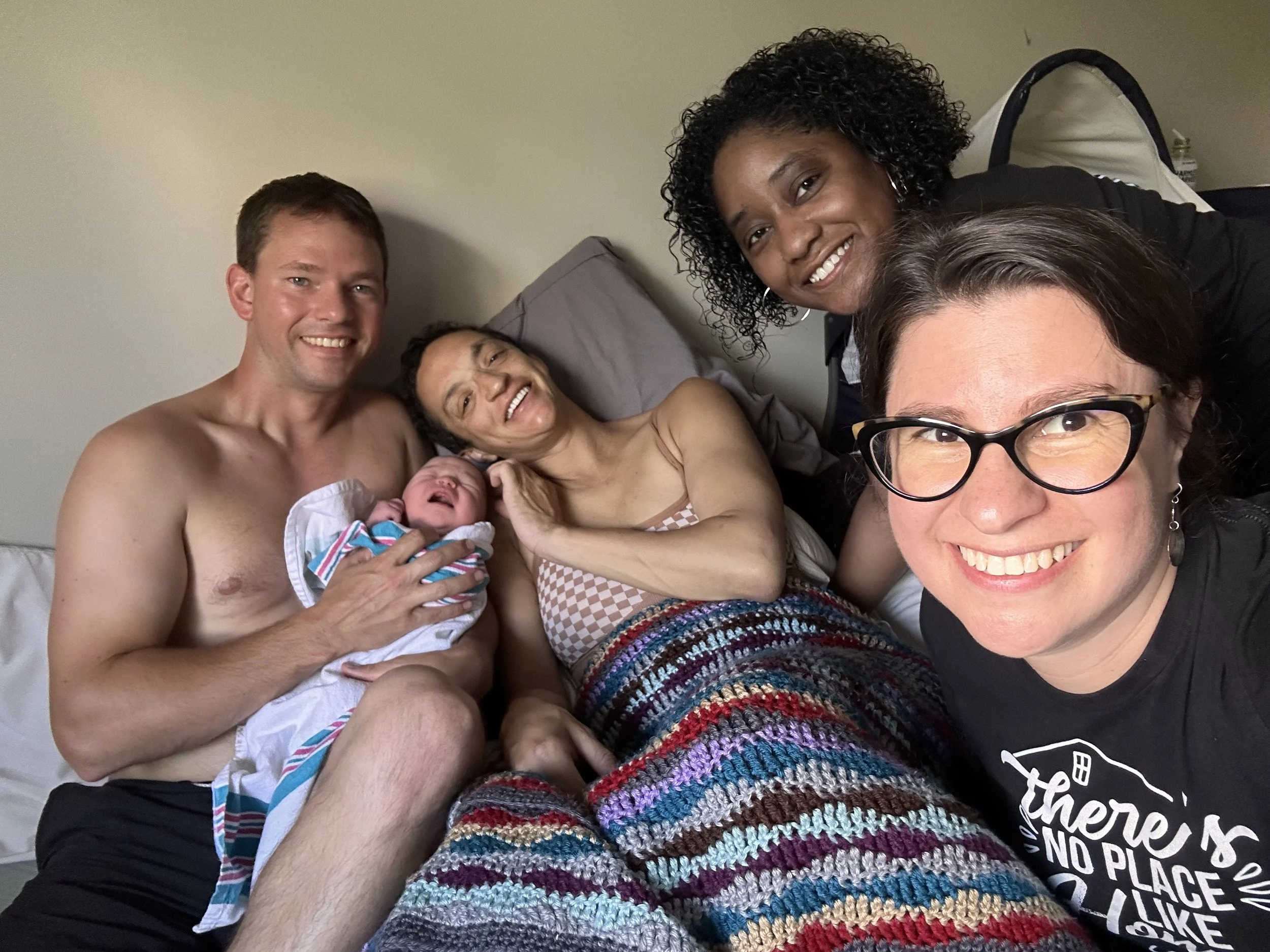 mom, dad and baby with midwife and birth assistant 