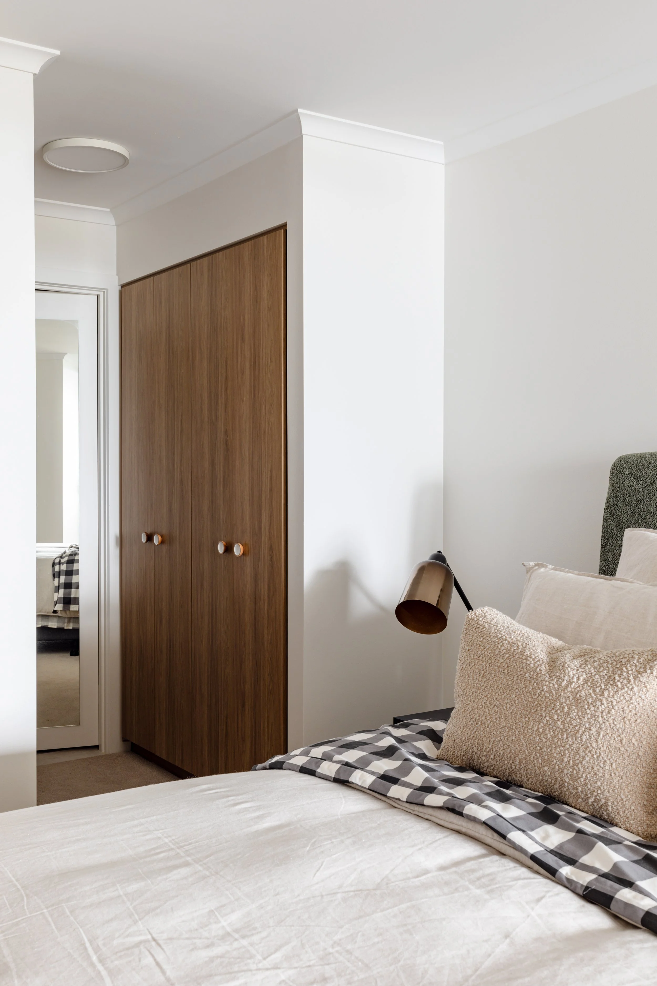 Bedroom close up showing wardrobe doors and styled bed