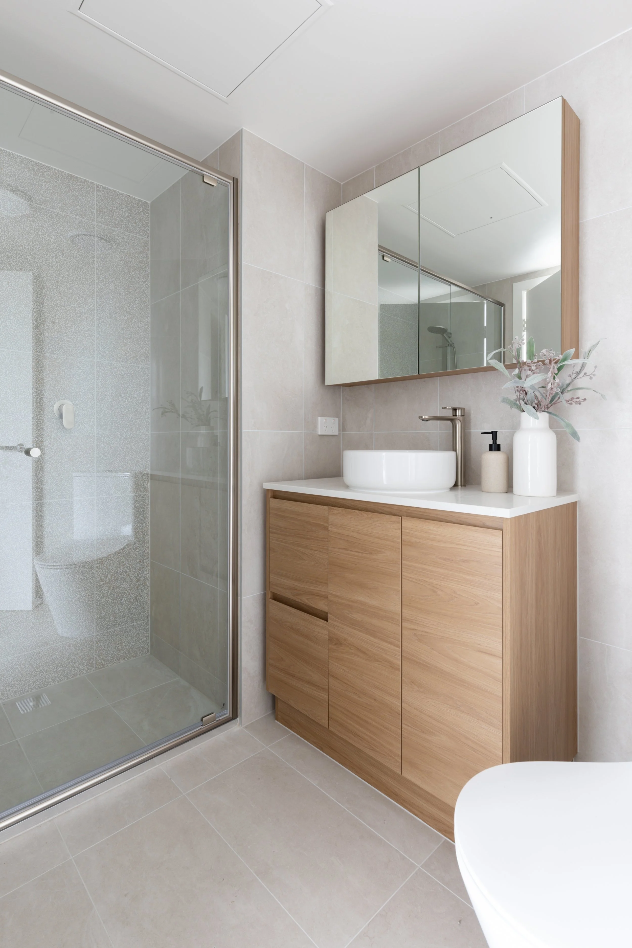 Refurbished bathroom with new vanity, mirror with storage, full height tiling