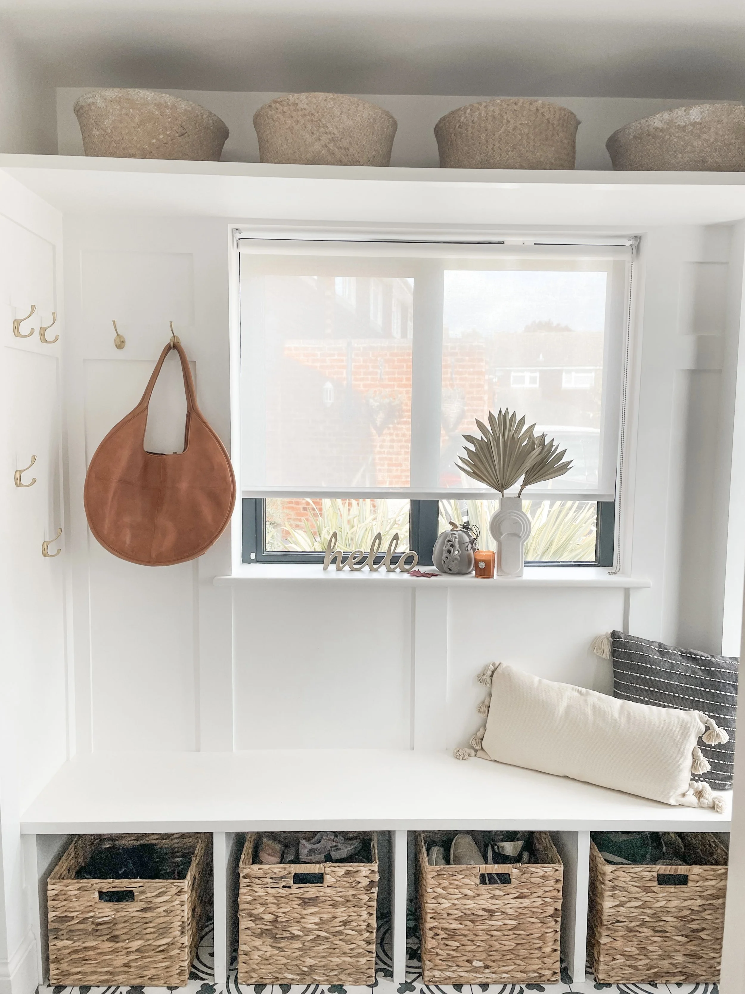 Mudroom with white panelling and baskets