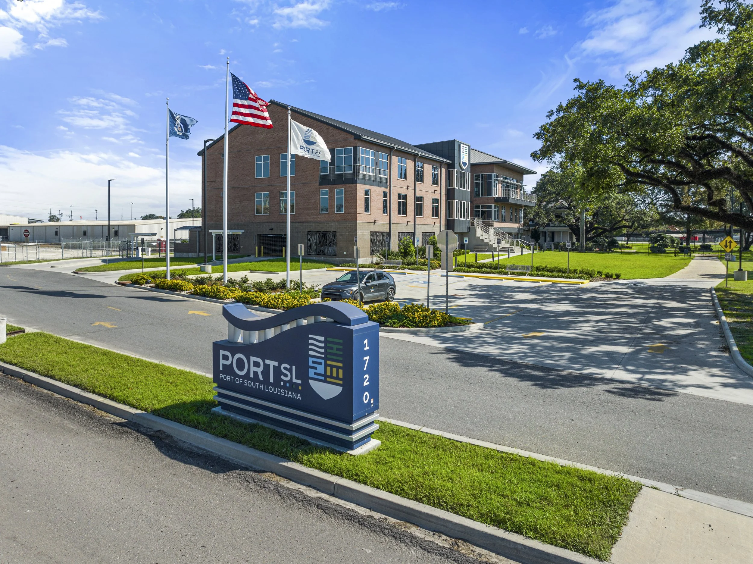 Exterior view of the Port of South Louisiana building with flags flying in front, a parking lot, and well-maintained landscaping.