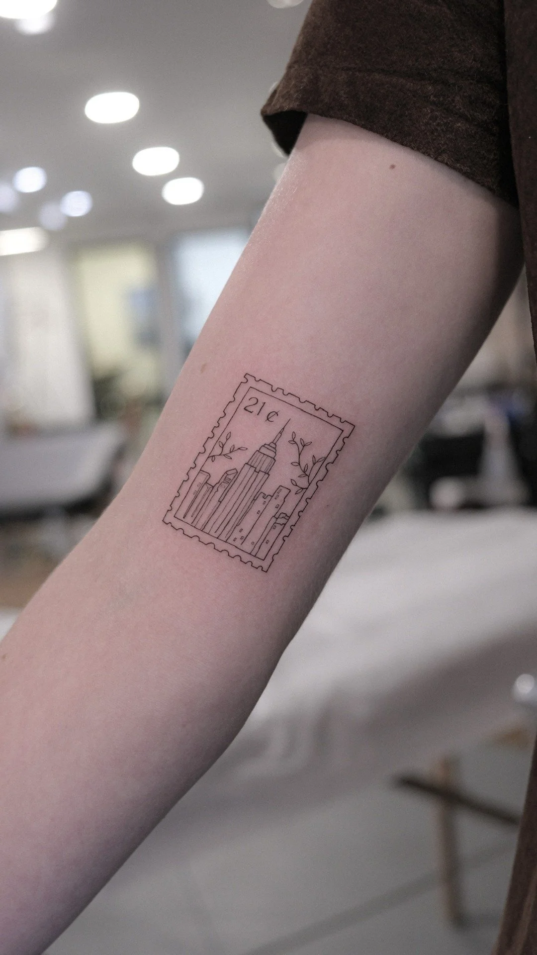 Fineline Tattoo of Stamp with NYC Skyline with numbers on it