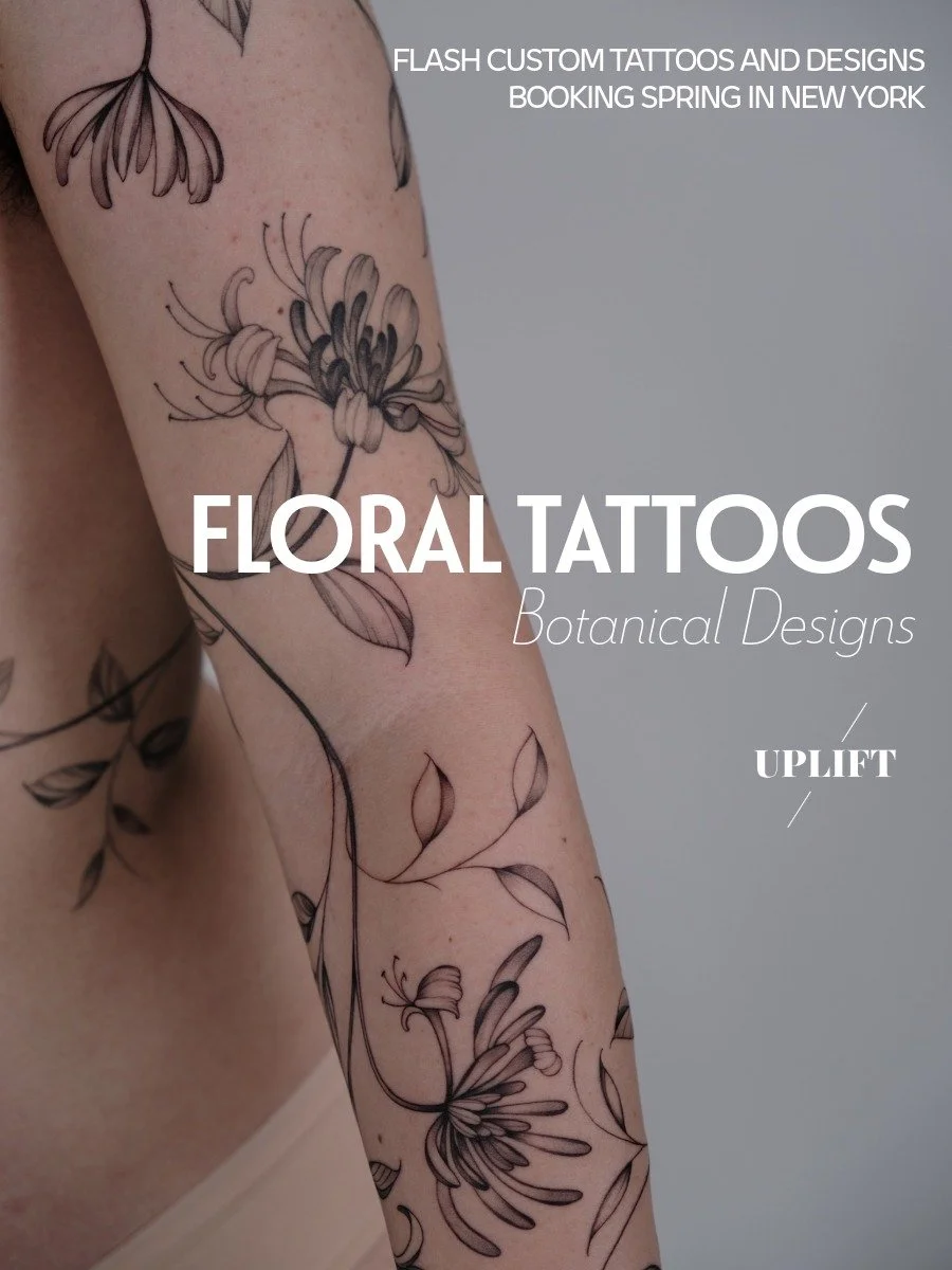 Close-up of floral tattoos on a person's arm, featuring delicate botanical designs with flowers and leaves on light skin.