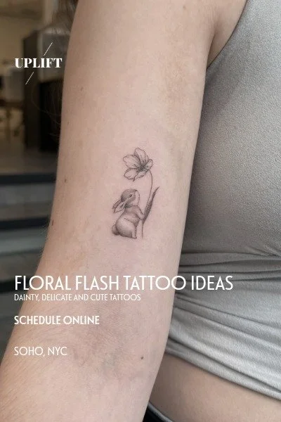 Small floral flash tattoo of a bunny with a flower on its head on a person's upper arm.