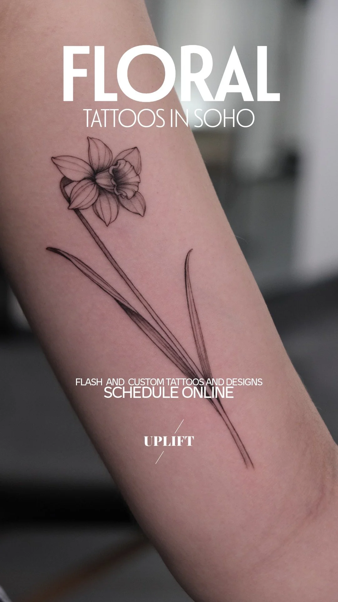 A black ink floral tattoo of a daffodil flower on a person's arm.