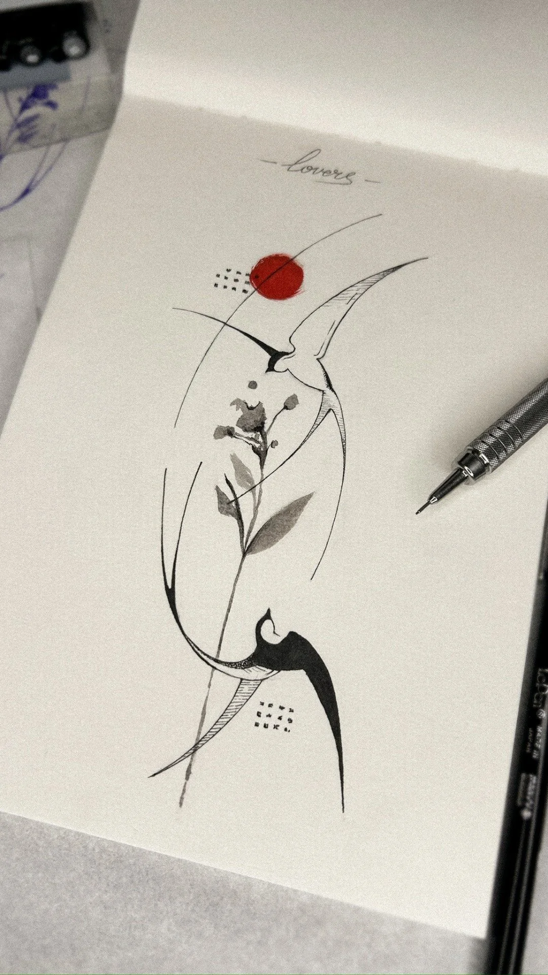 A sketch of a hummingbird near a flower with the word 'loves' written above. The artwork includes a red circle and small dotted designs, with a pen placed beside the drawing.