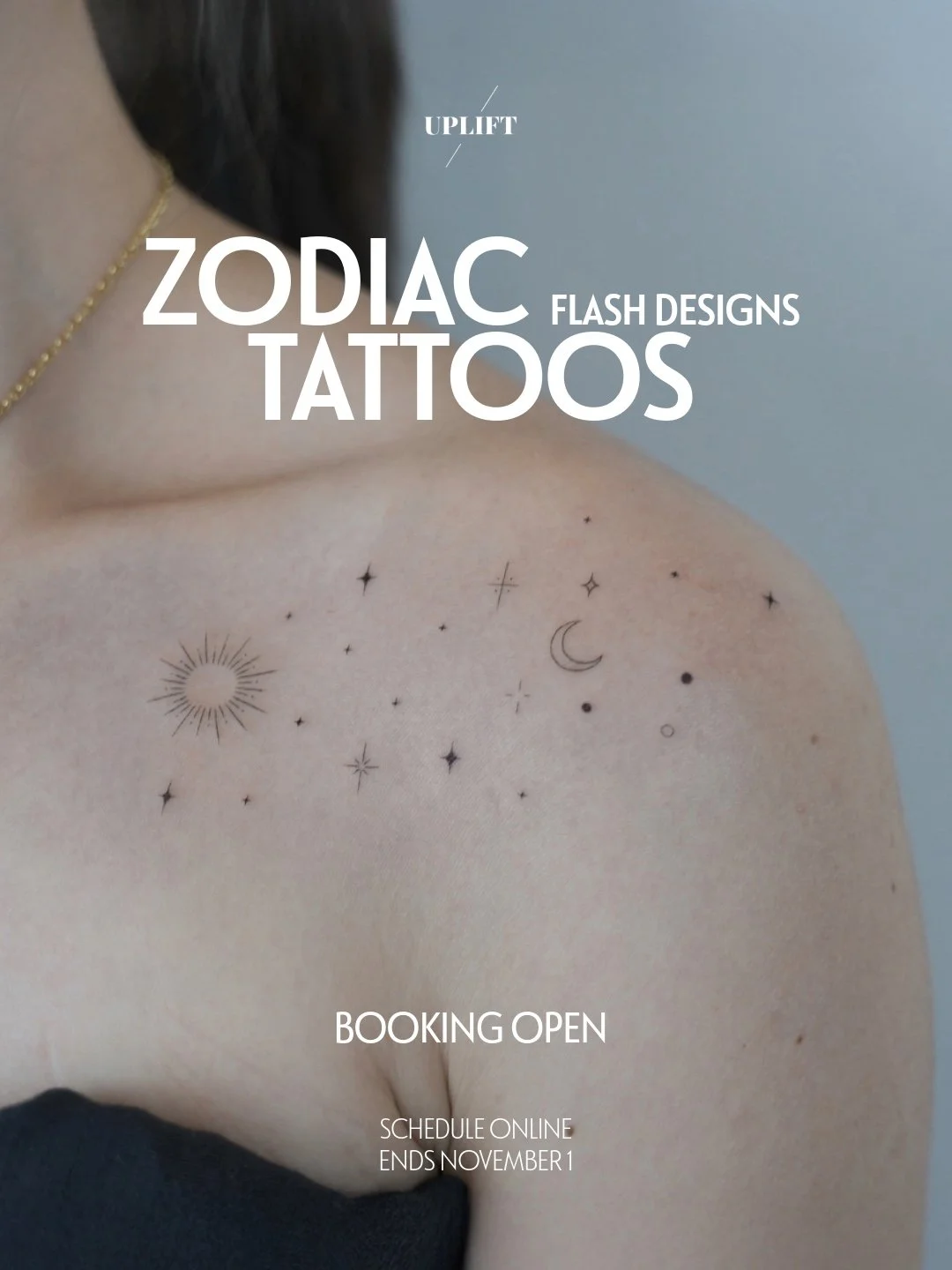 Tattooed shoulder with zodiac-themed designs including sun, moon, stars, and small celestial symbols.