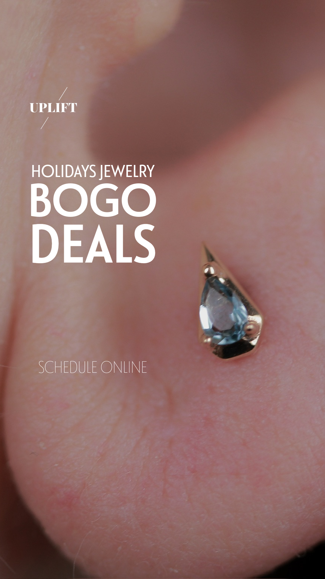 Close-up of a person's nose with a small, shiny, teardrop-shaped gemstone nose piercing, overlaid with promotional text for holiday jewelry BOGO deals and a call to schedule online.