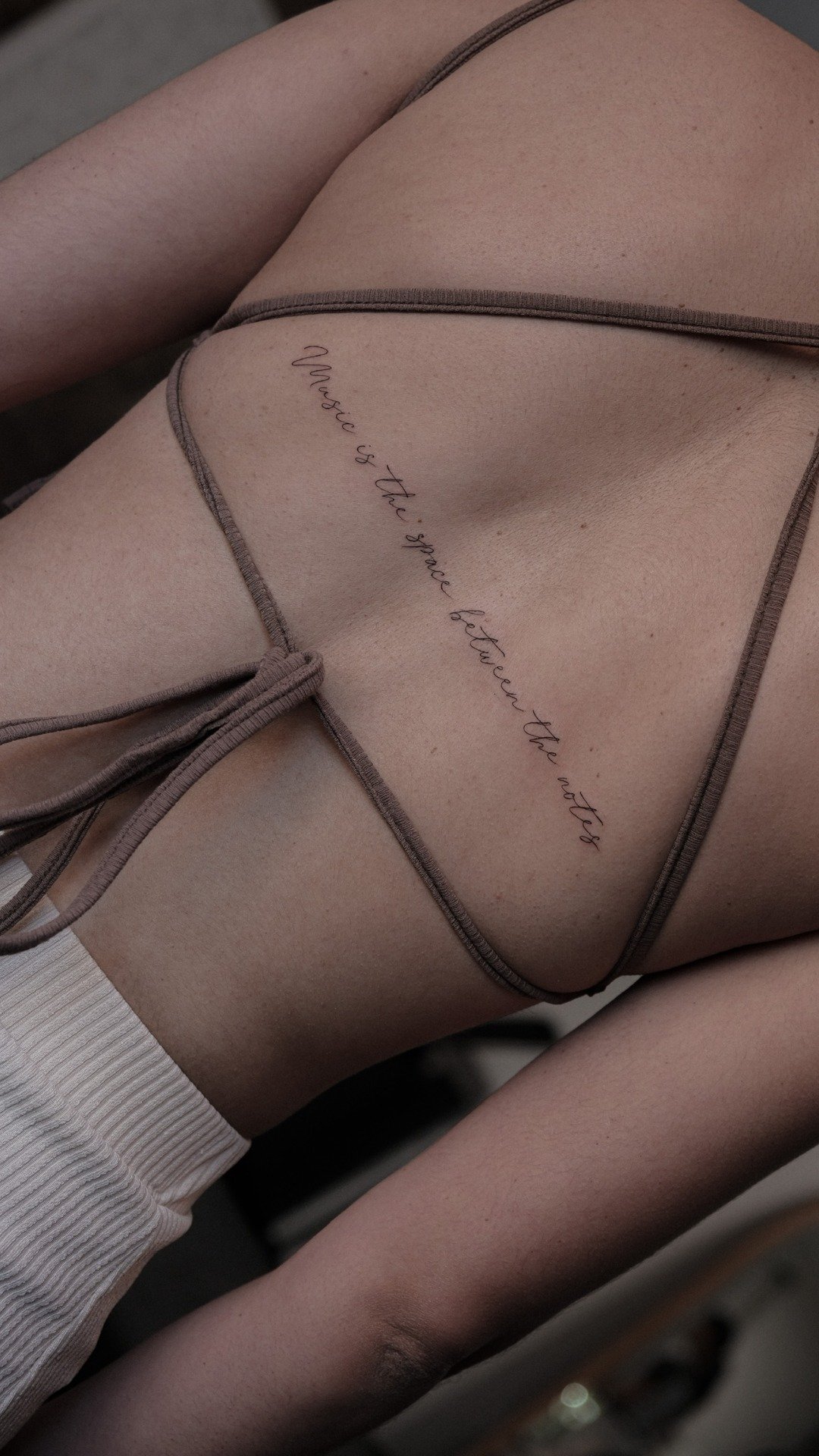 Fine line script tattoo along the ribs at UPLIFT Tattoo & Piercing in SoHo NYC.