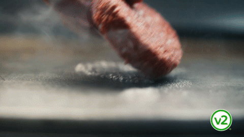 Close-up of a finger pressing down on a surface, causing a small indentation in the material.