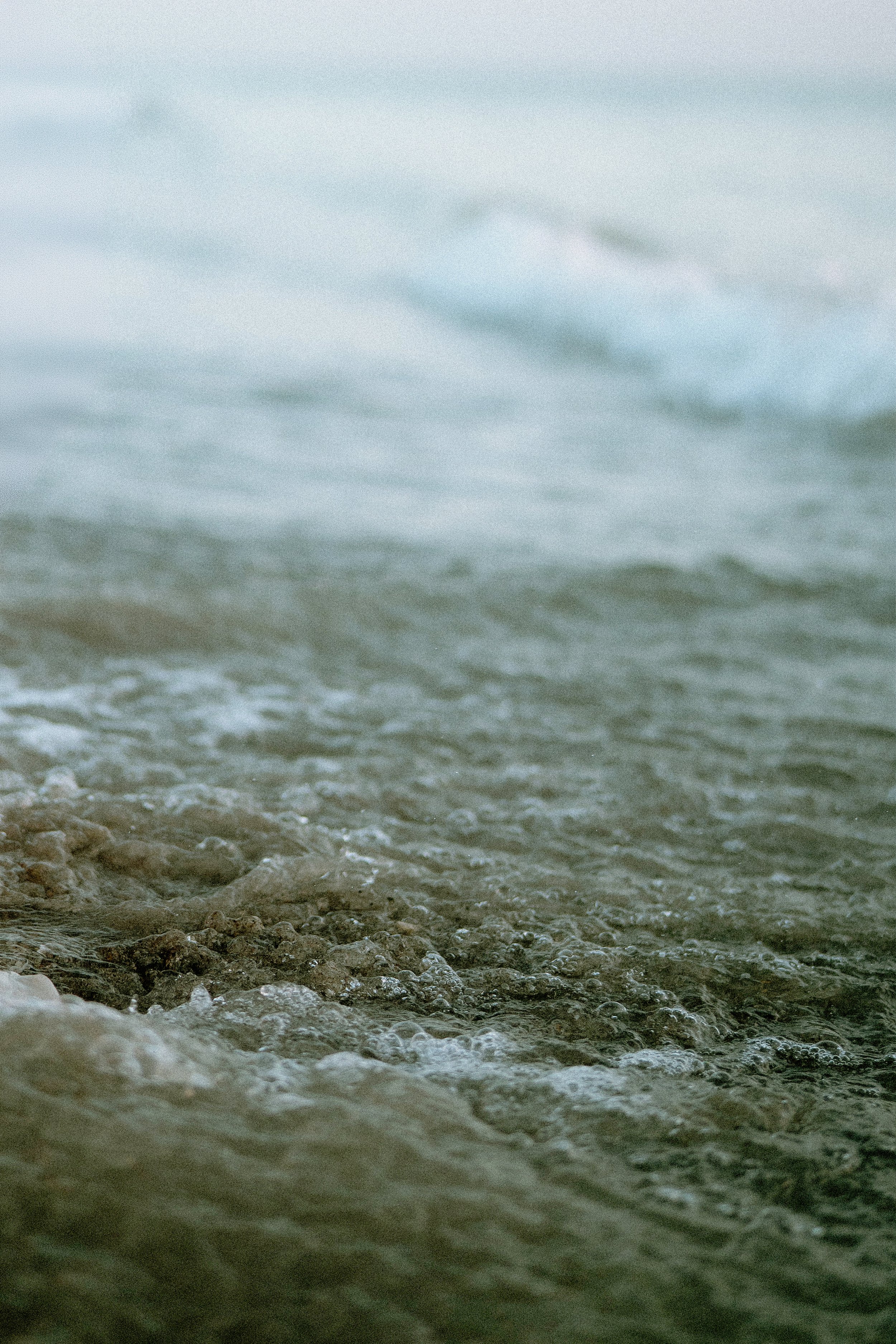 Close-up of water washing over rocks on a shoreline.