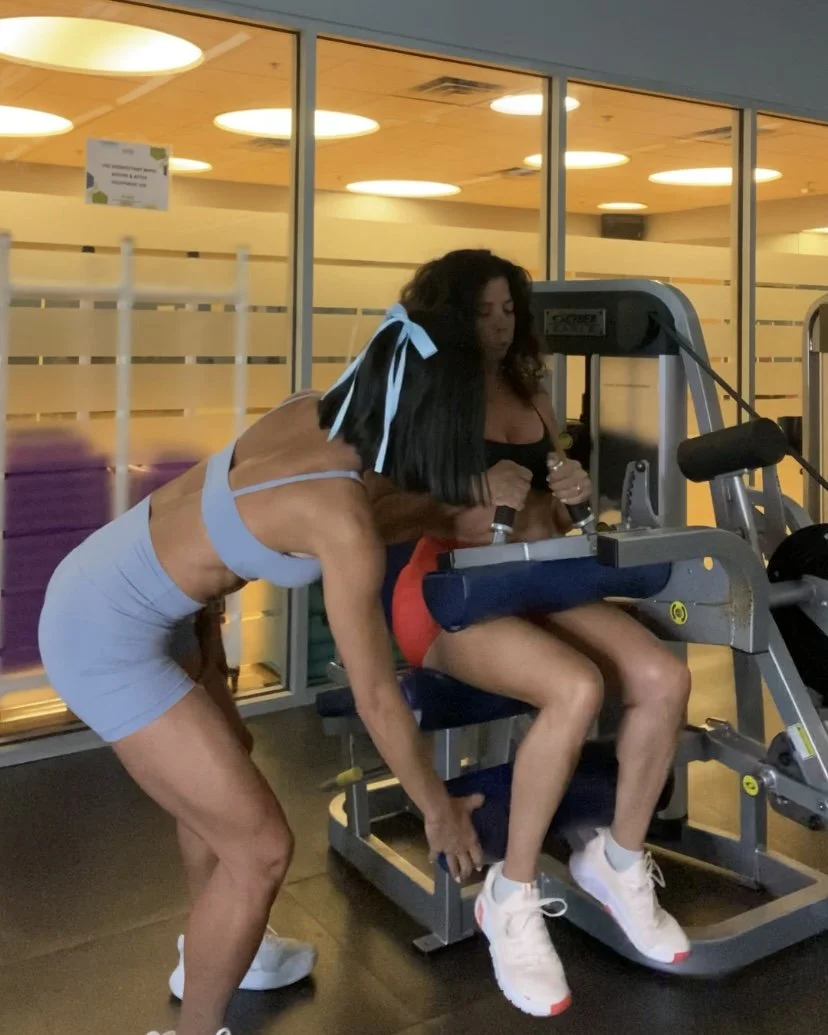 Trainer assisting hamstring curl exercise to improve glute strength and form