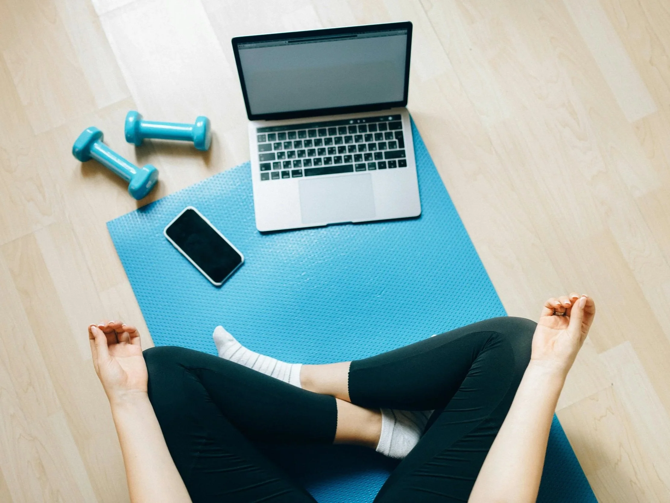 Home workout on yoga mat following online coaching program on laptop