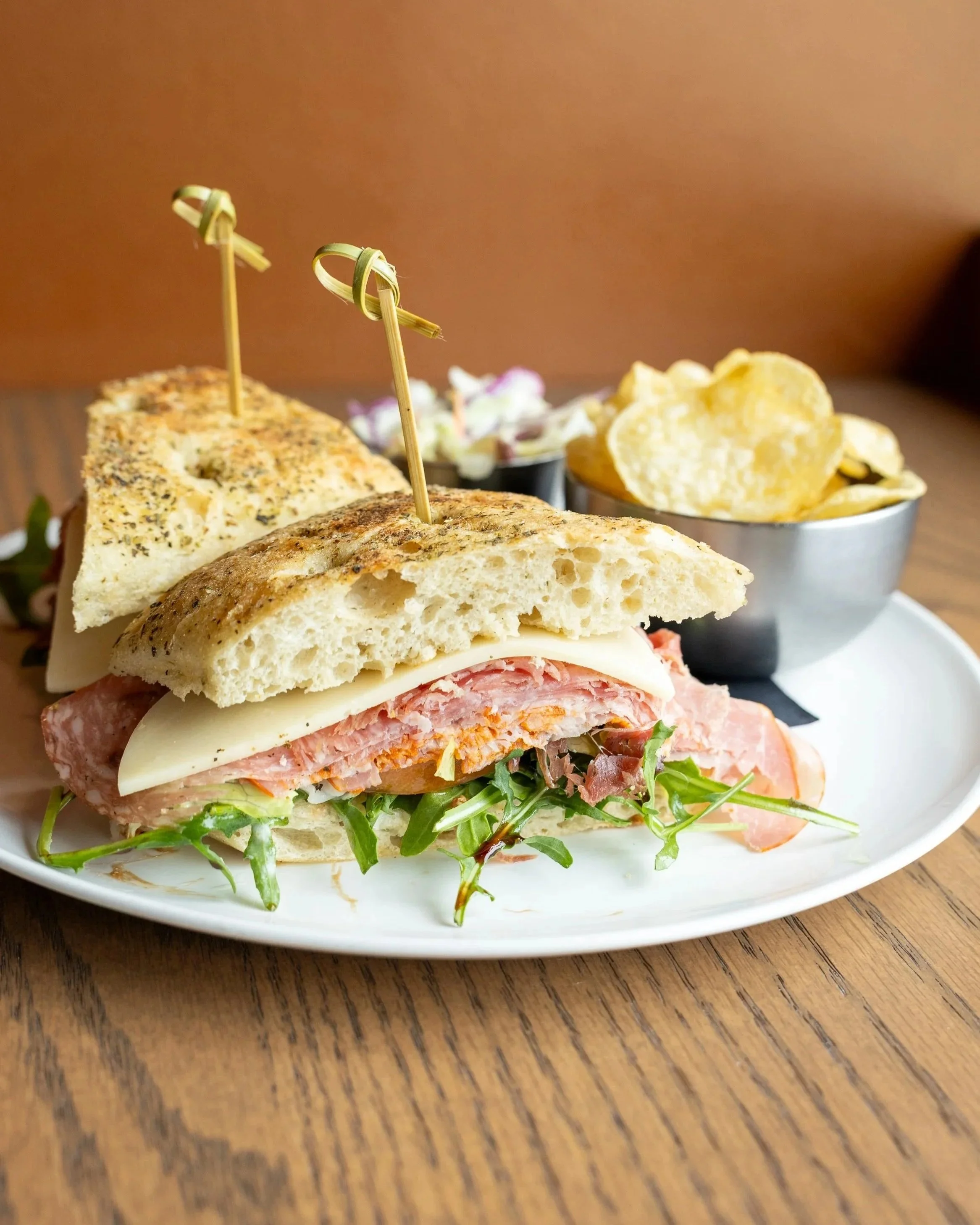  Italian Sandwich 
Ciabatta bun piled high with salami, capicola, and prosciutto, topped with arugula, tomatoes, red onions, provolone cheese, and finished with a balsamic dressing. 