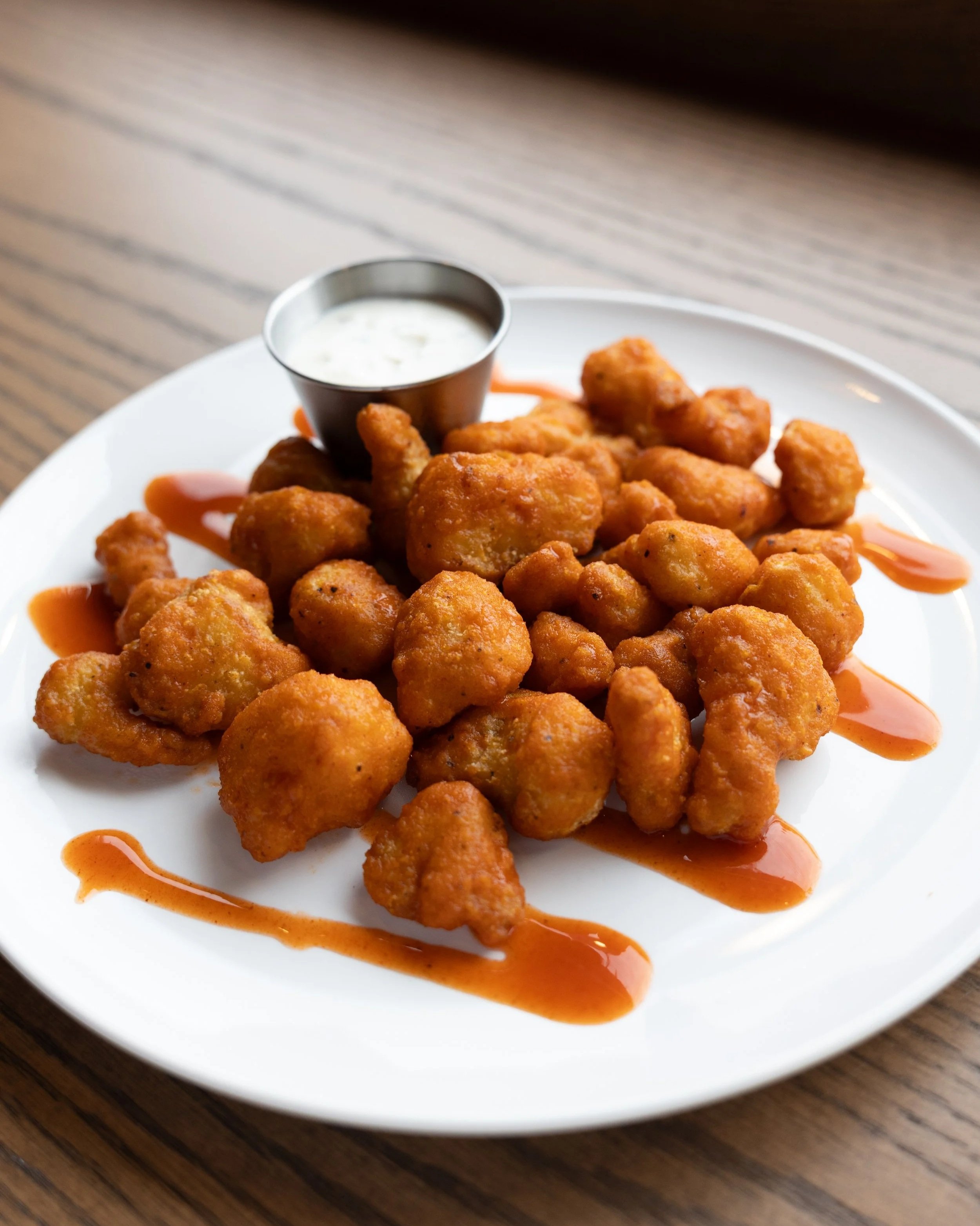  Buffalo Cauliflower Bites 
Crispy battered cauliflower tossed in buffalo sauce, served with ranch. 