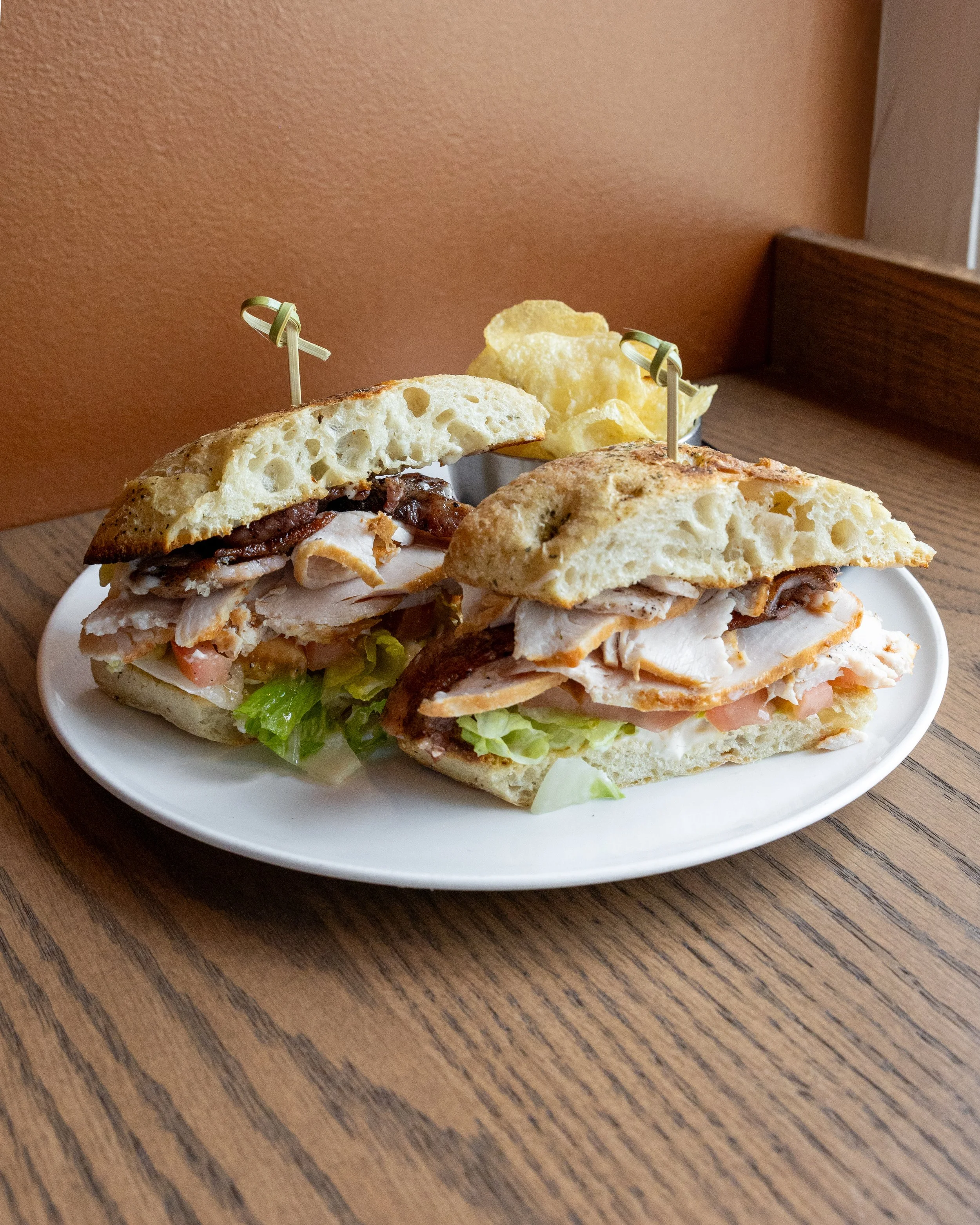  Turkey Club 
Sliced turkey layered with crispy bacon, lettuce, tomatoes, and mayonnaise on a fresh ciabatta bun.
