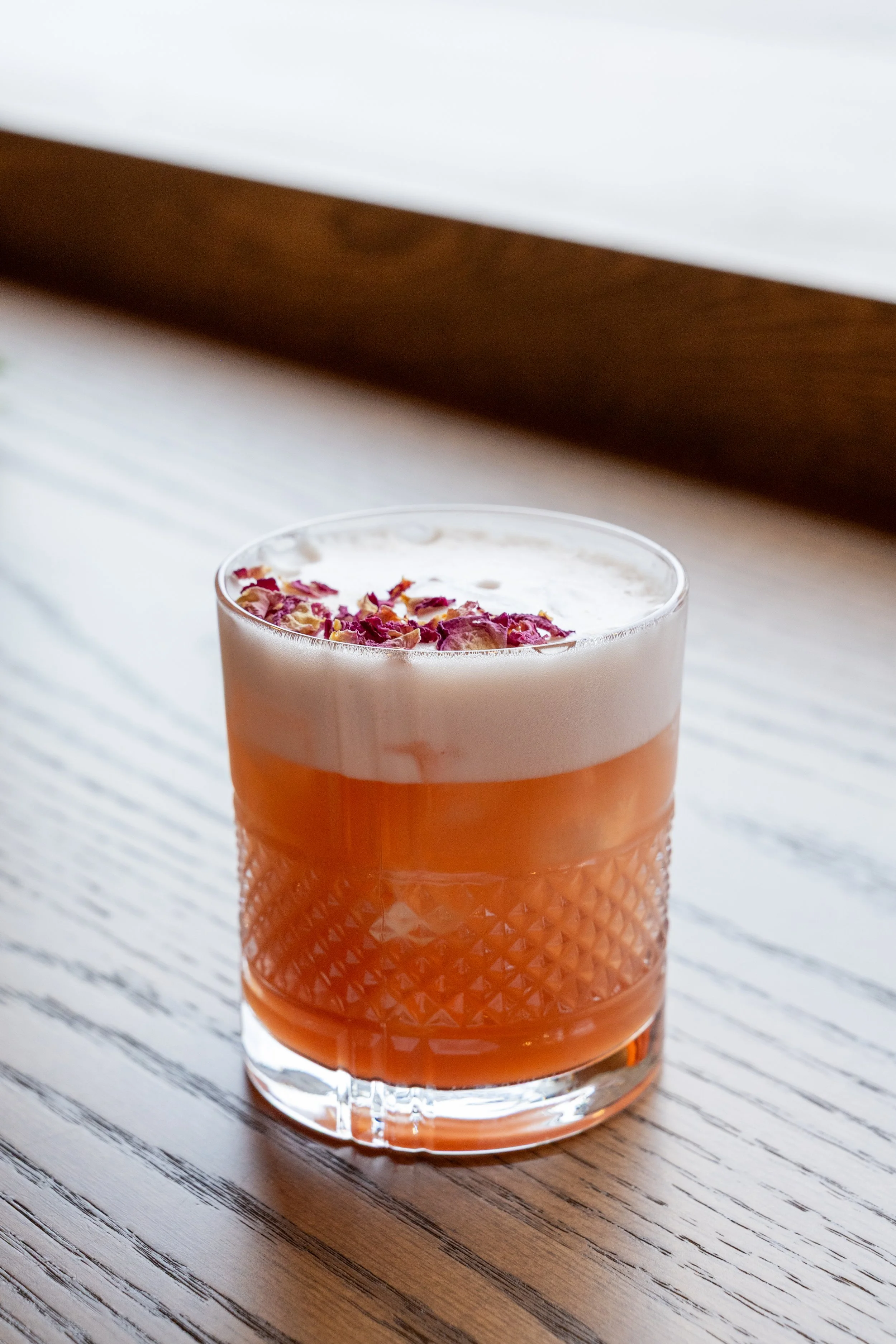  Hibiscus Sour 
Whiskey, sweet & sour, egg whites & hibiscus syrup. Garnished with dried flower petals