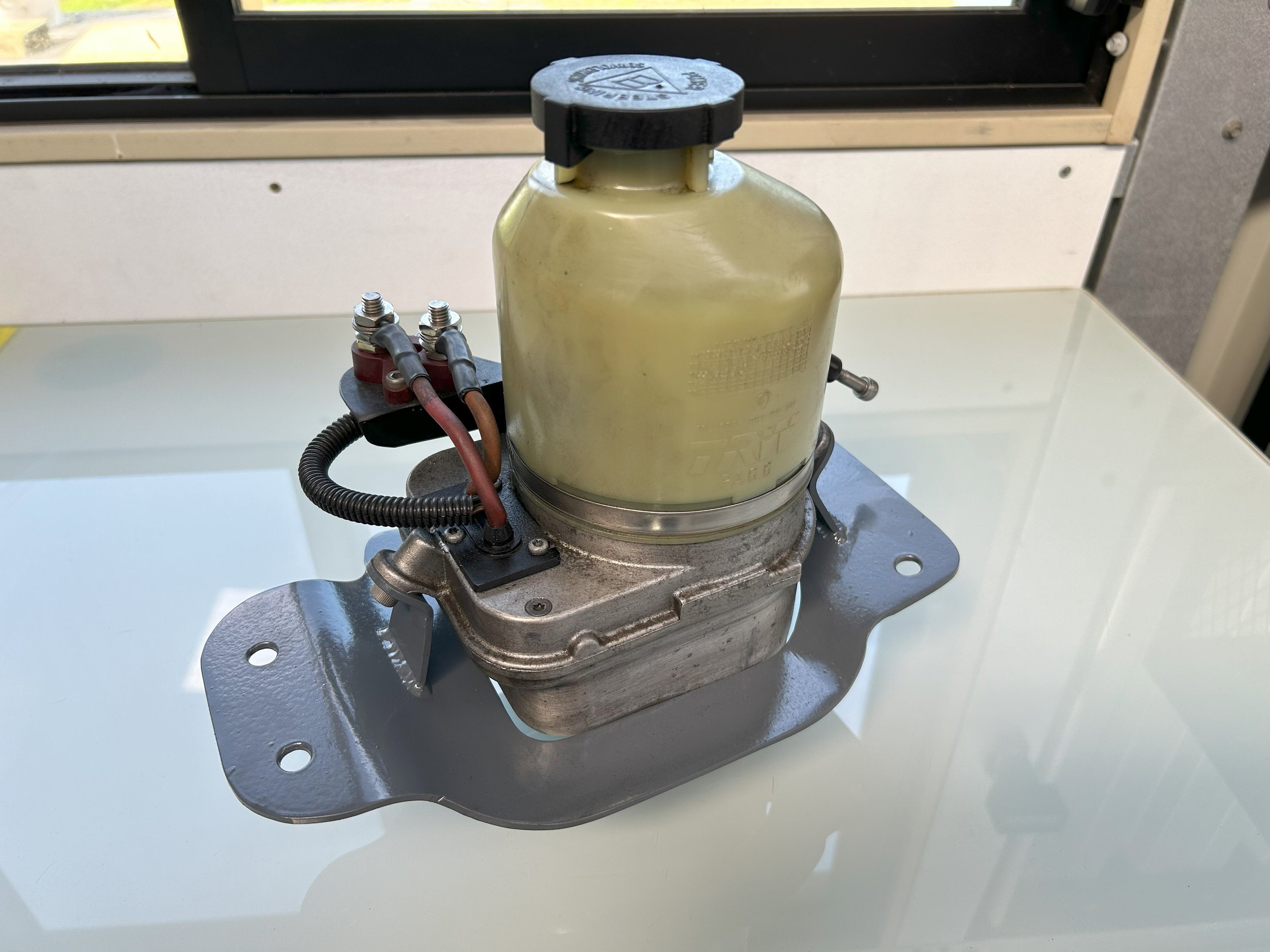 Astra power steering pump mount for relocation to back seat shelf of racecar, folded to match floor profile.