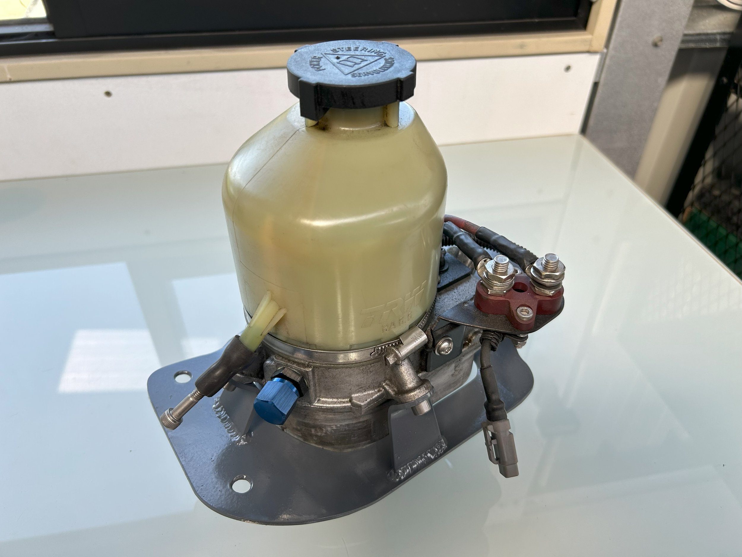 Astra power steering pump mount for relocation to back seat shelf of racecar, folded to match floor profile.