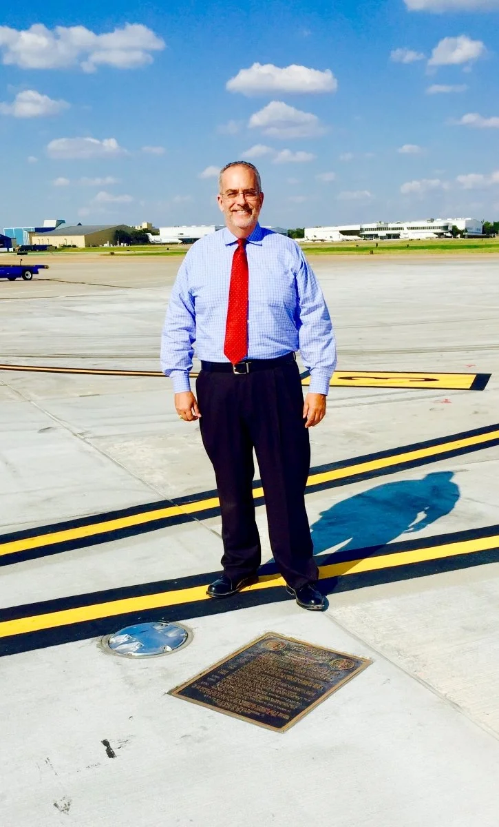 Farris Rookstool posing in front on Lyndon B. Anthony plaque