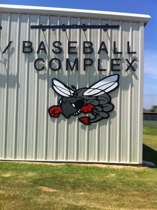 Custom architectural signage installed on a baseball complex building featuring dimensional letters and mascot graphics, demonstrating durable building signage designed to complement modern architecture.