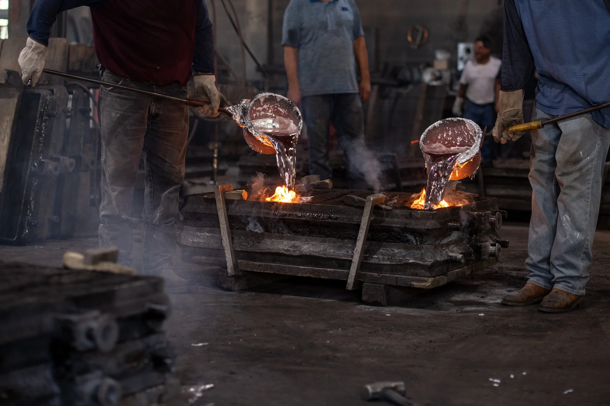 Molten metal being poured into molds during the cast plaque production process.