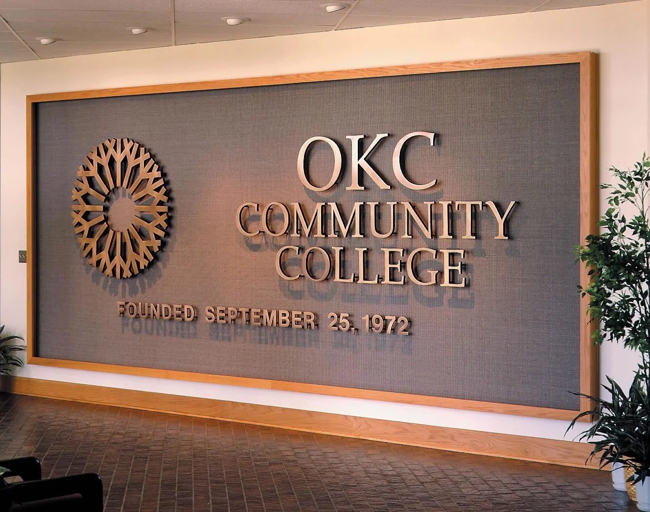 American made cast metal letters displaying OKC Community College branding on an interior architectural wall.