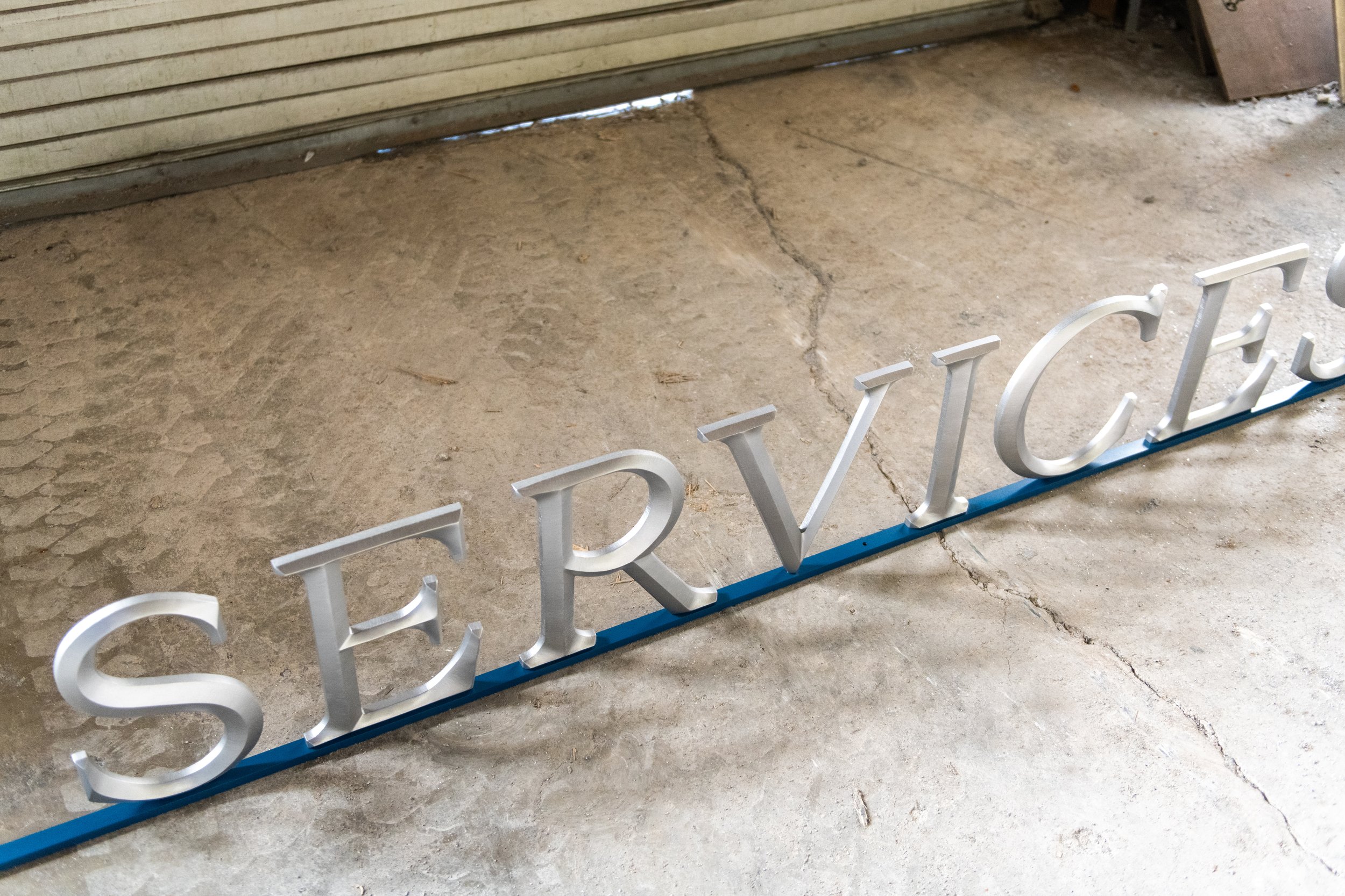 Custom aluminum letters spelling “SERVICES,” fabricated by A.R.K. Ramos for business signage.