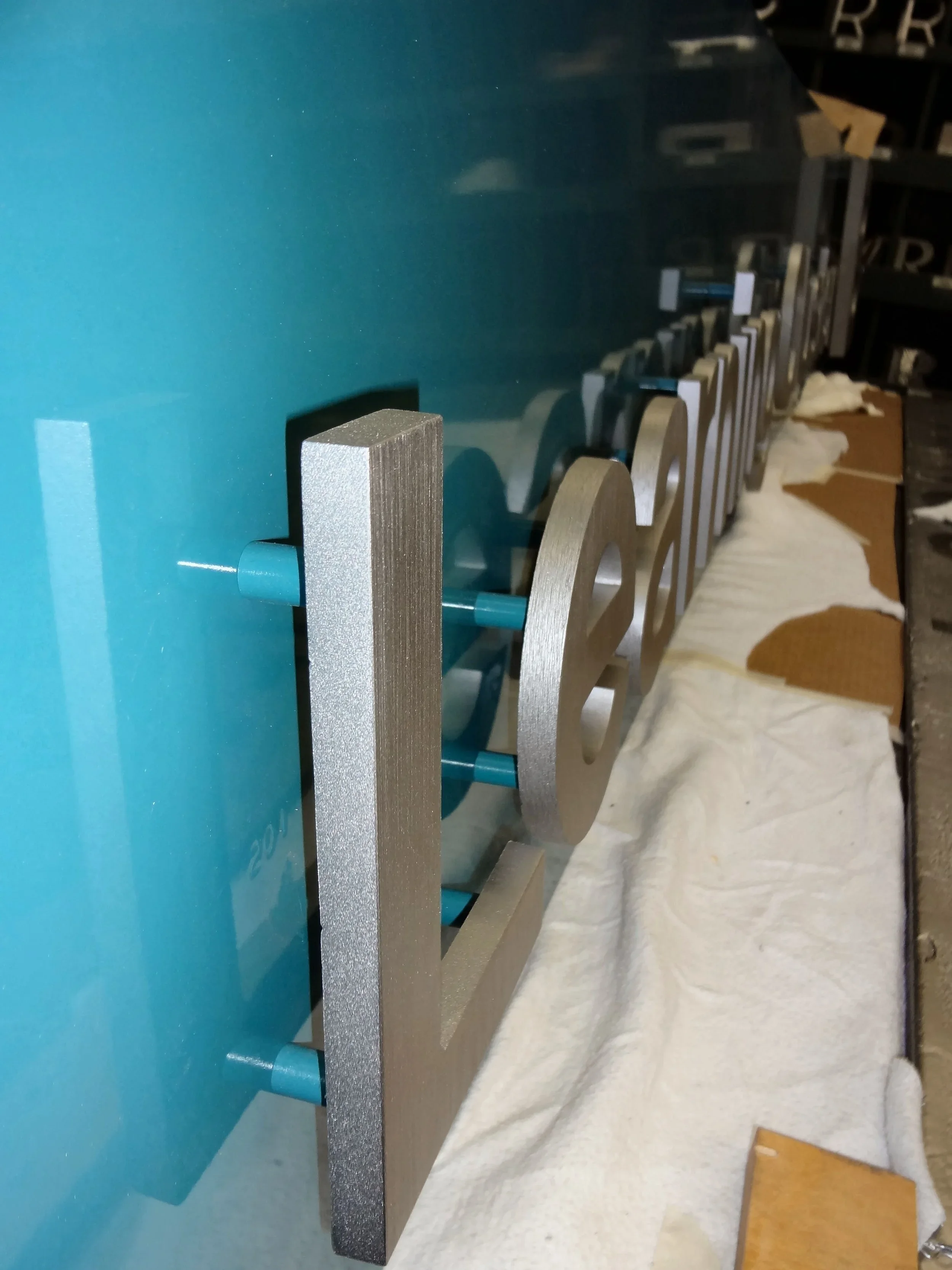 Custom fabricated dimensional metal letters mounted to a sign panel, demonstrating durable signage construction and professional outdoor signage installation.