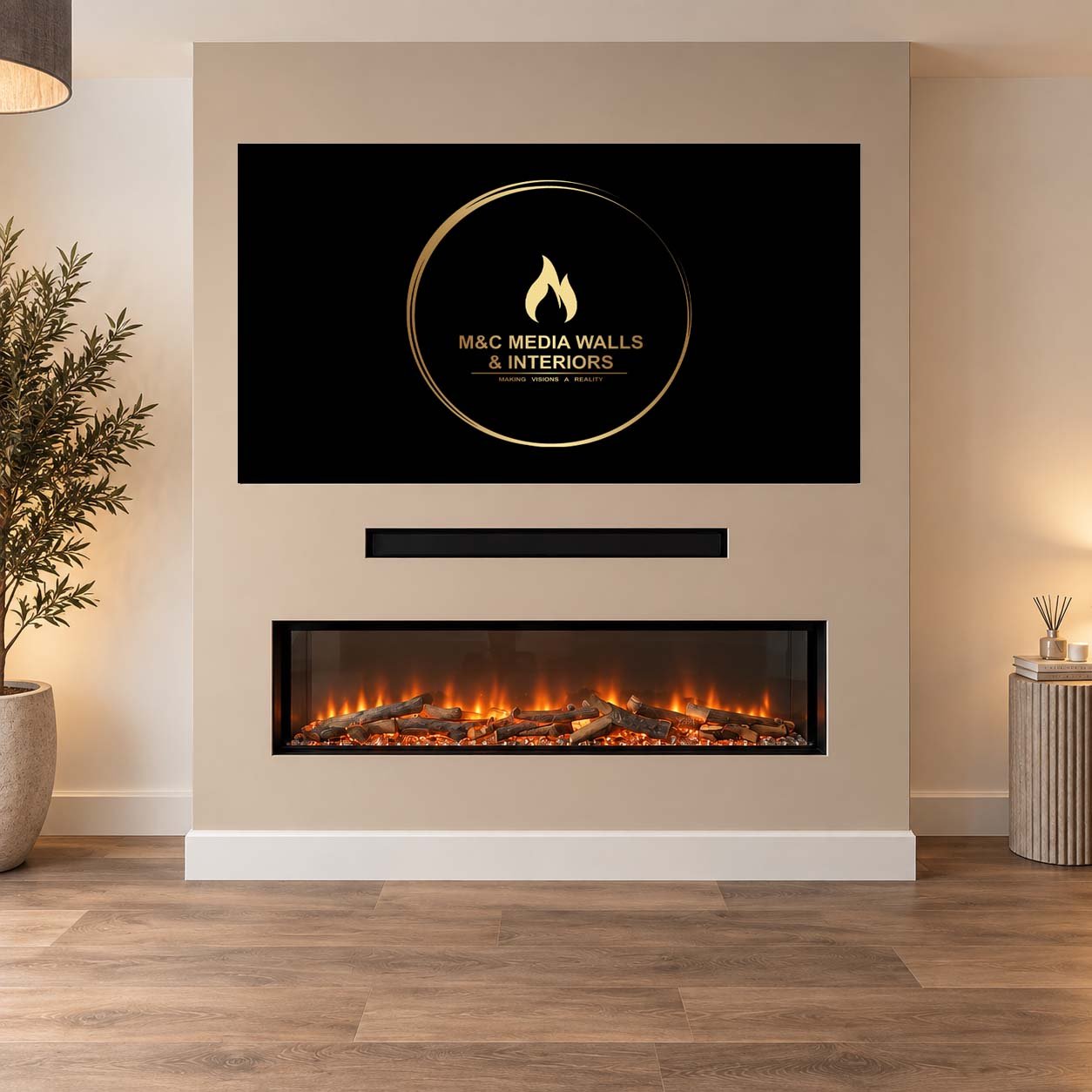 Living room with a modern fireplace, wall-mounted TV displaying the logo for M&C Media Walls & Interiors, a potted plant on the left, and a wooden side table with a reed diffuser and candles on the right.