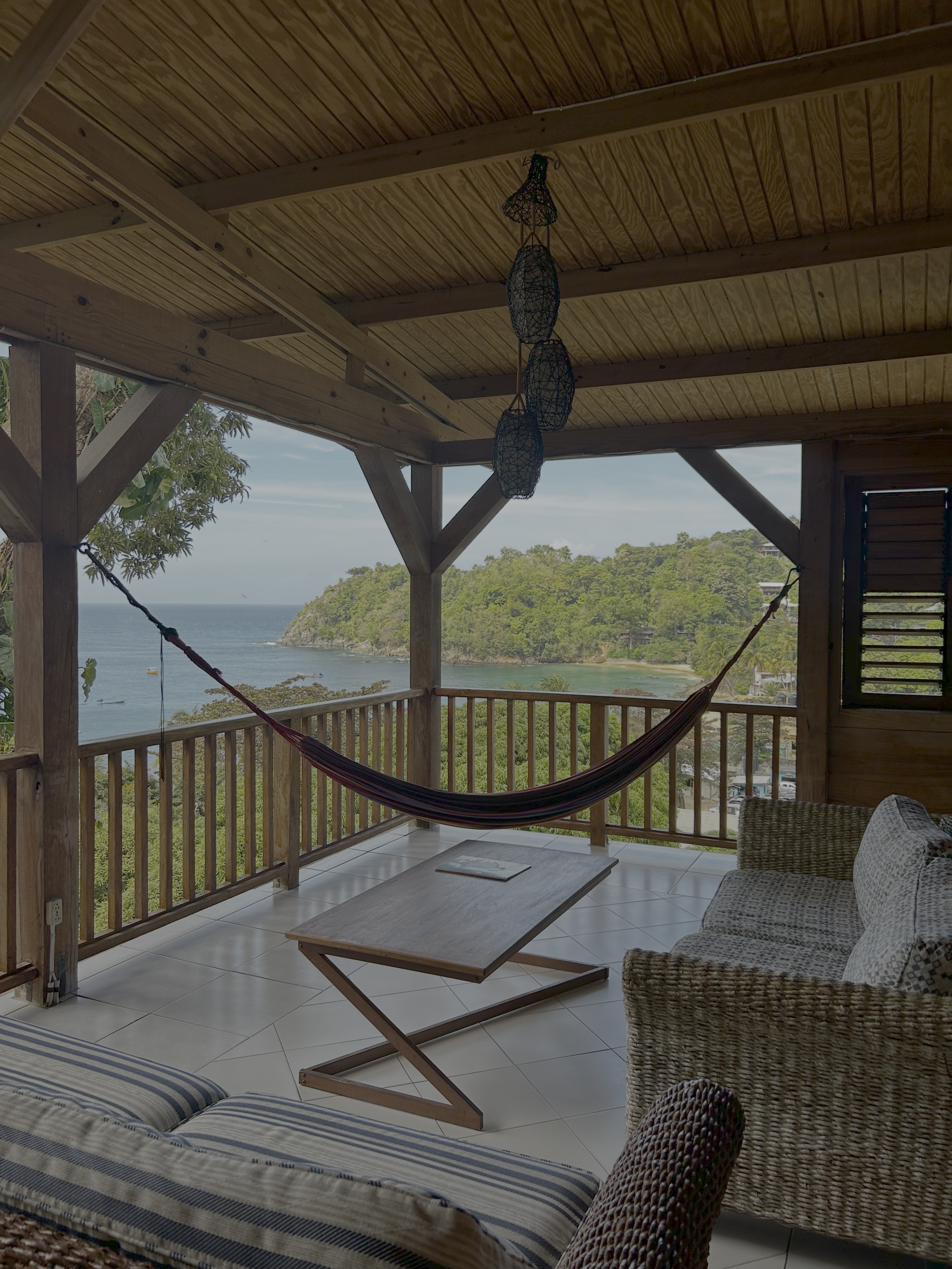 Wooden veranda with a hammock at Castara Retreats, overlooking Castara Bay and the Caribbean Sea, Tobago, home of the Together we Breathe wellbeing retreat