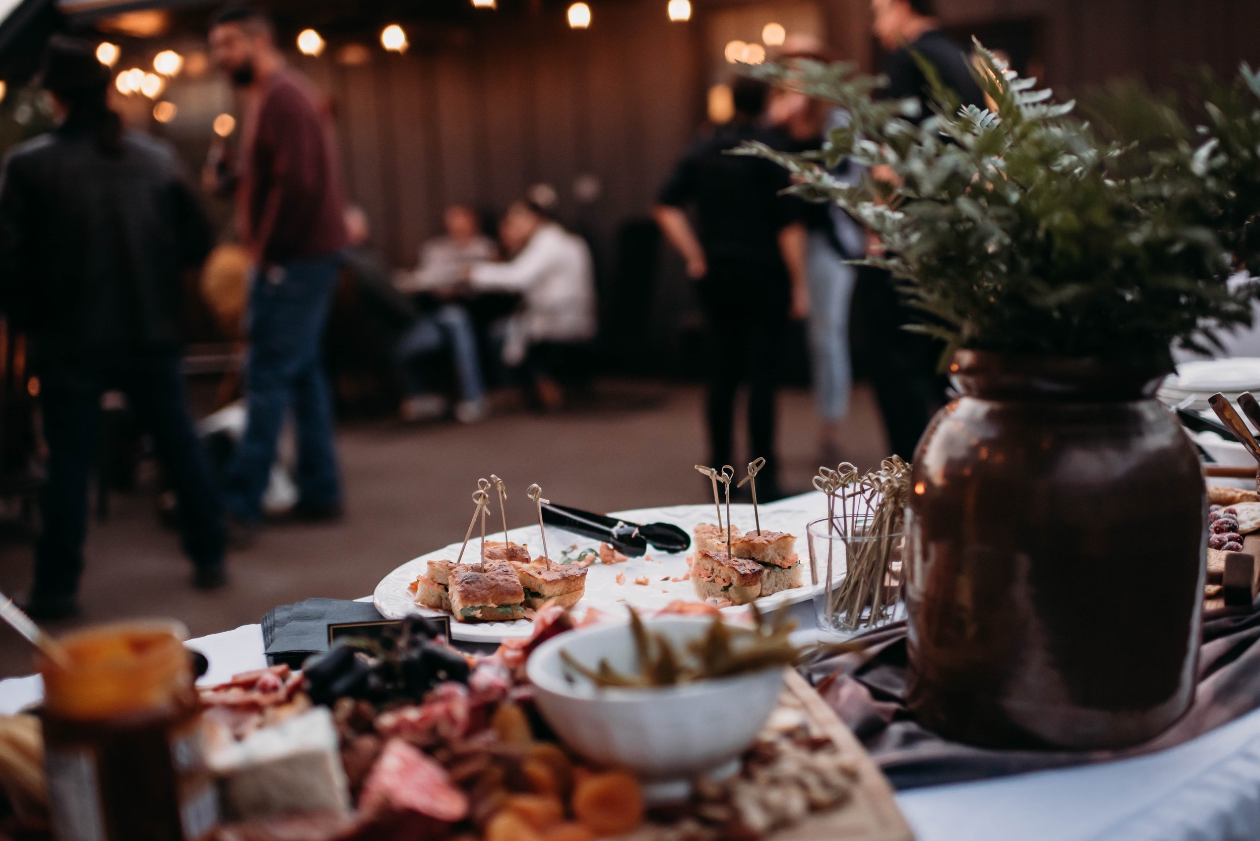 Appetizers and small bites set on a buffet table with guests mingling in the background at a cozy unique wedding venue in Indiana.