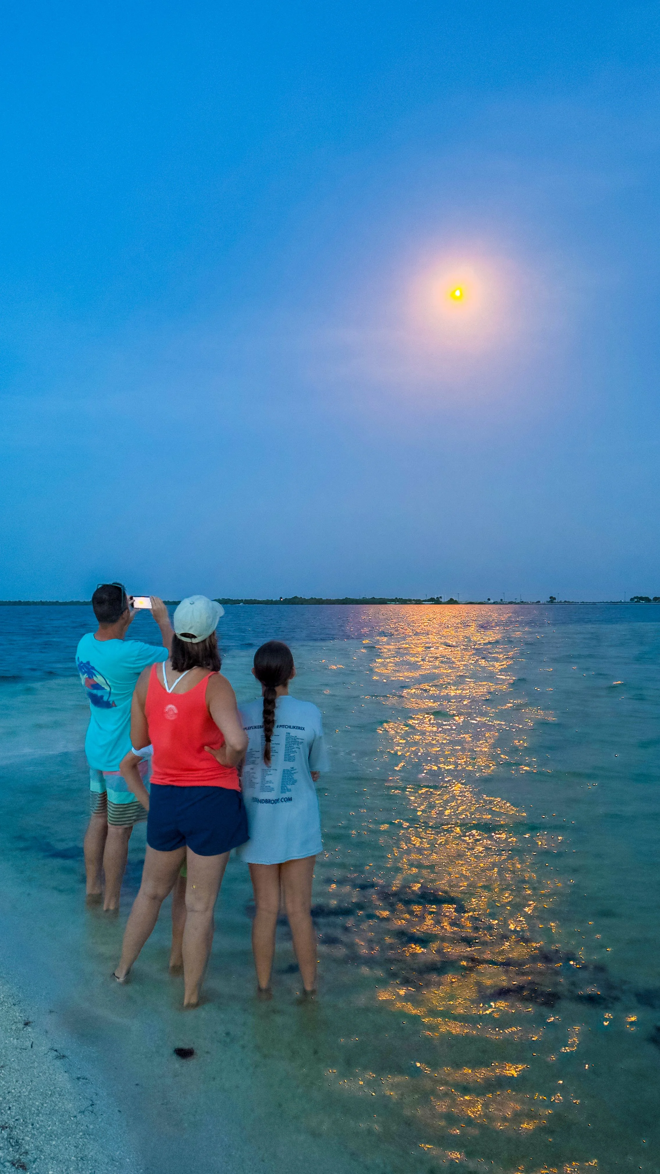 Family enjoying a beginner-friendly nighttime paddleboard tour with bioluminescence.