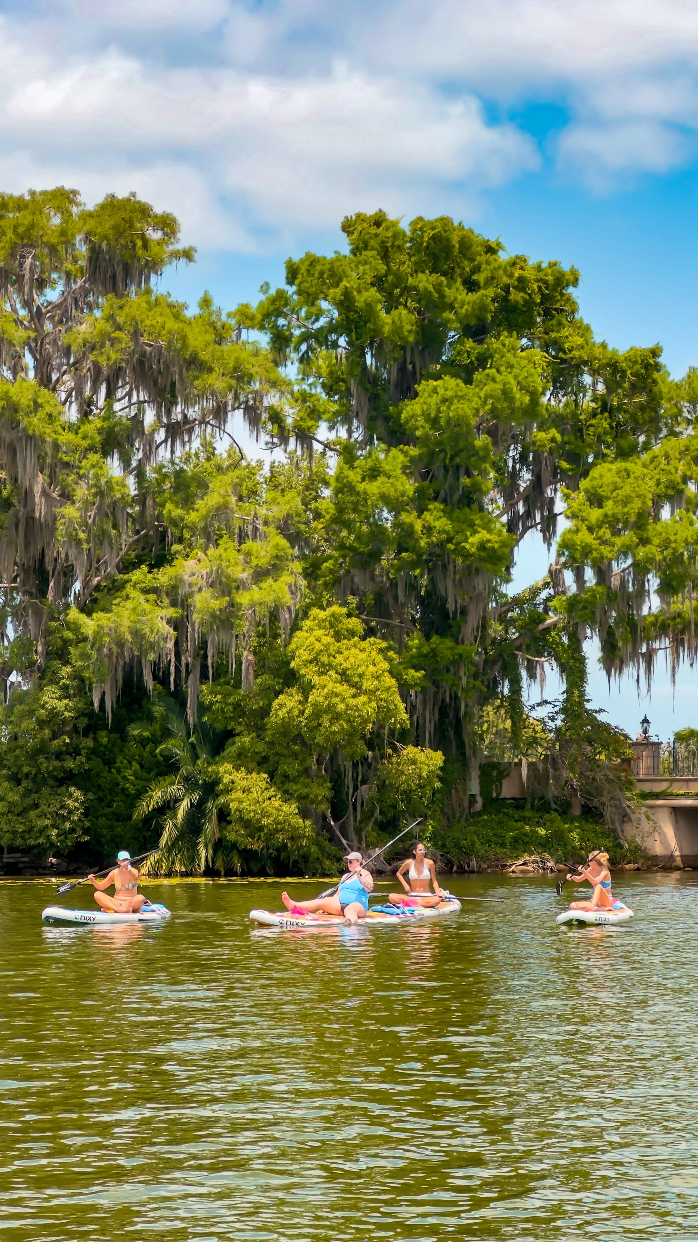 Group of women paddleboarding on Winter Park Chain of Lakes in Orlando, Florida – guided sunset paddle tour with Otter Paddle Orlando