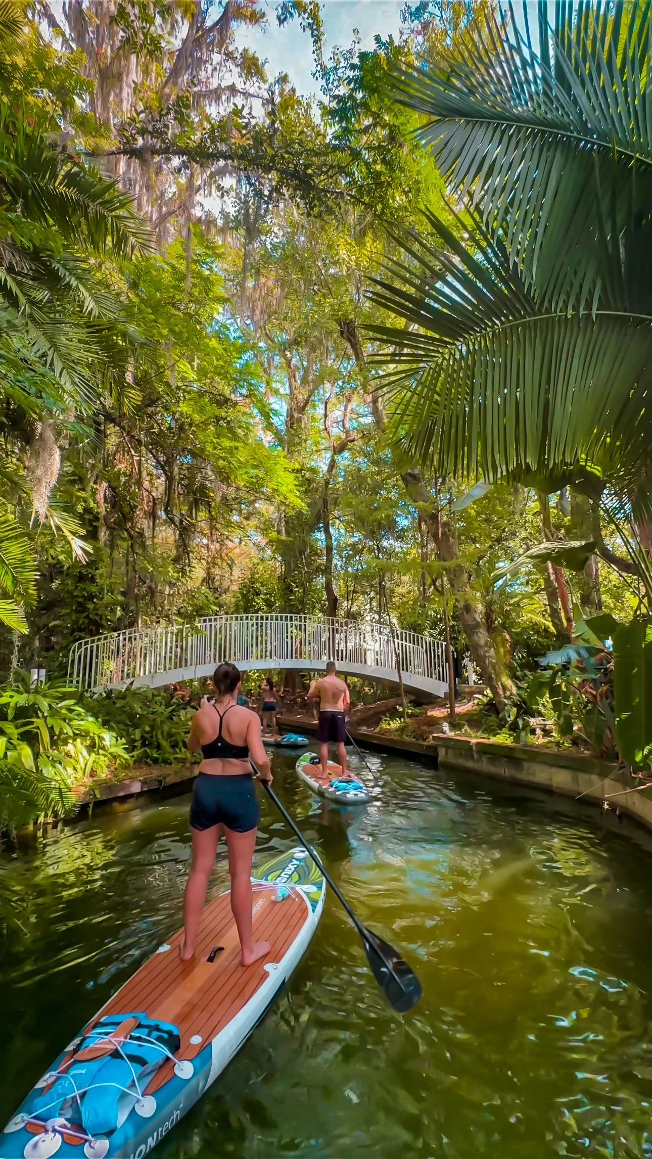 Paddleboarders exploring scenic Venetian-style canals on the Winter Park Chain of Lakes with Otter Paddle Orlando