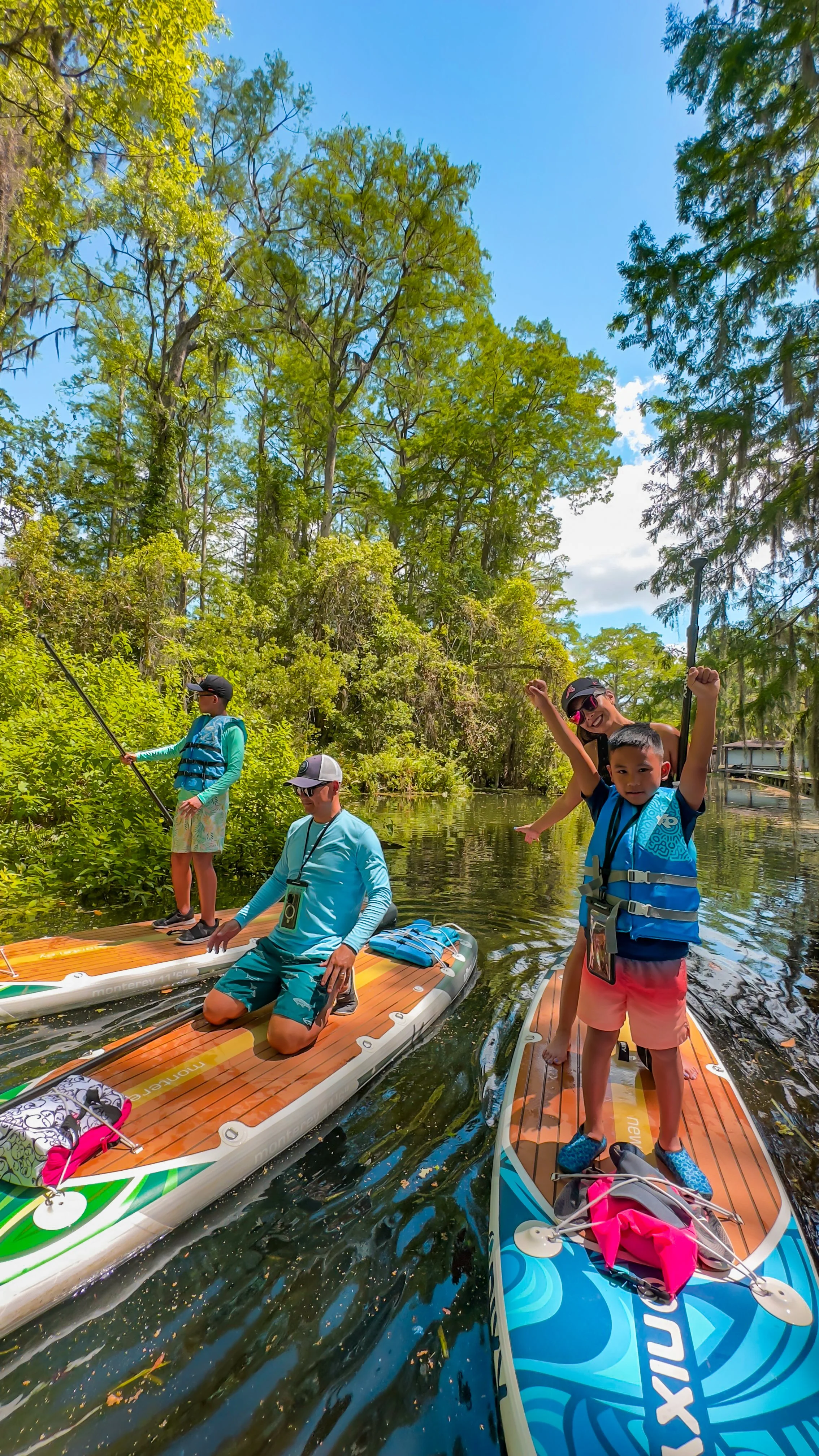 Family paddleboarding on Winter Park Chain of Lakes – mom and child riding together on a paddleboard during a fun, guided tour with Otter Paddle Orlando