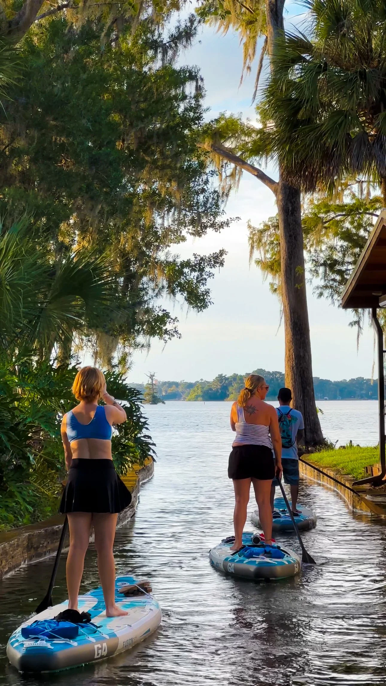 Paddleboarders exploring the scenic canals of the Winter Park Chain of Lakes on a guided paddle tour in Orlando, Florida.