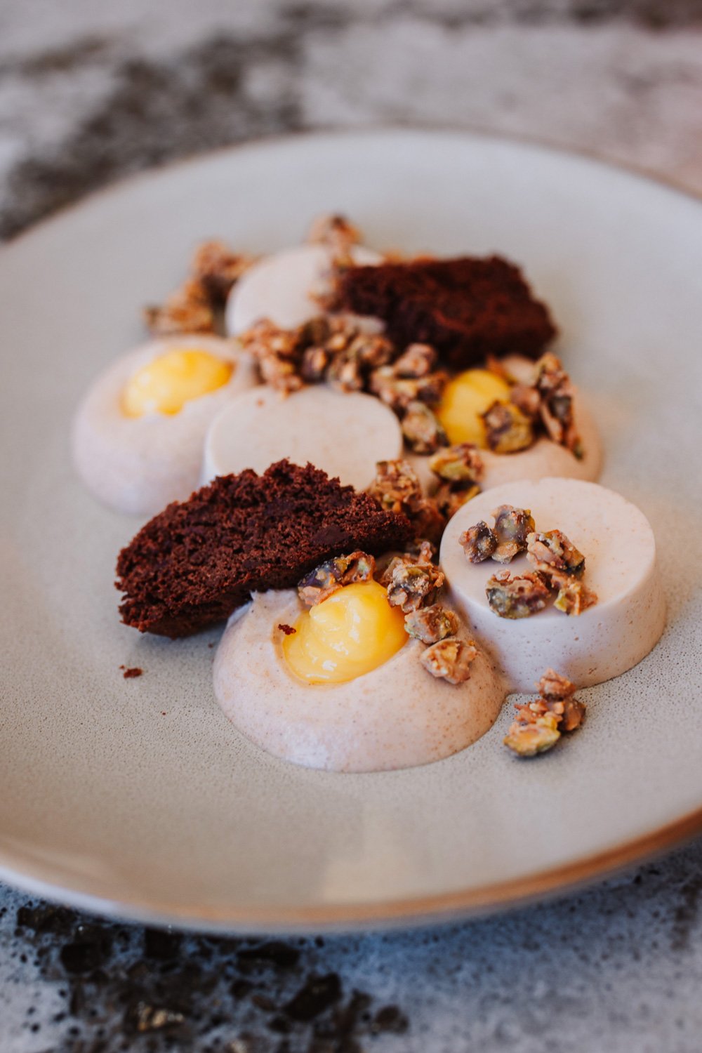 Panna Cotta alla Banana – banana panna cotta, pistachio-coconut crunch, lemon curd, cardamom mousse, and dark chocolate biscotti 
