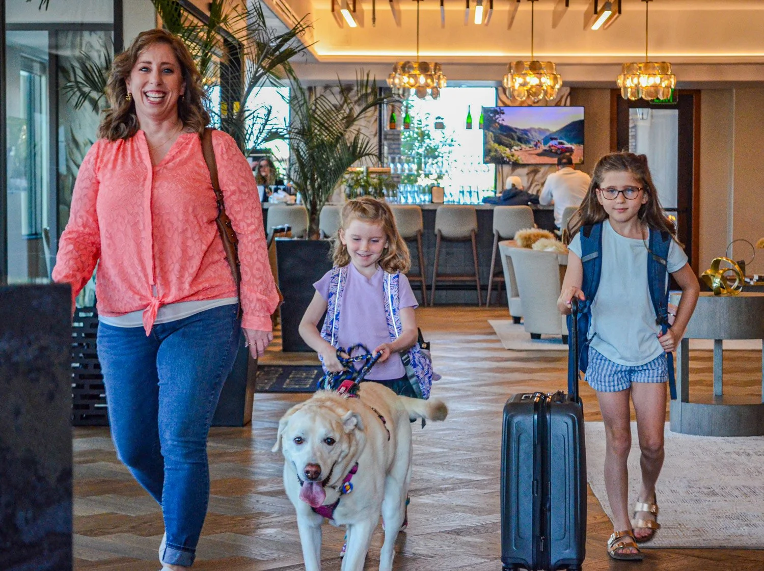 mom with her daughters and dog checking into the hotel