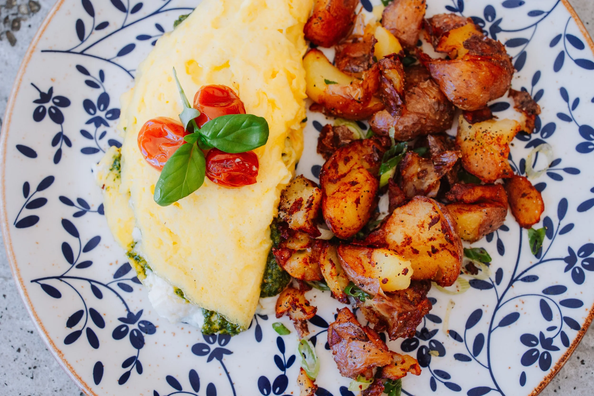 Pesto e Ricotta Omelette – pesto omelet, ricotta, confit tomato, signature potatoes